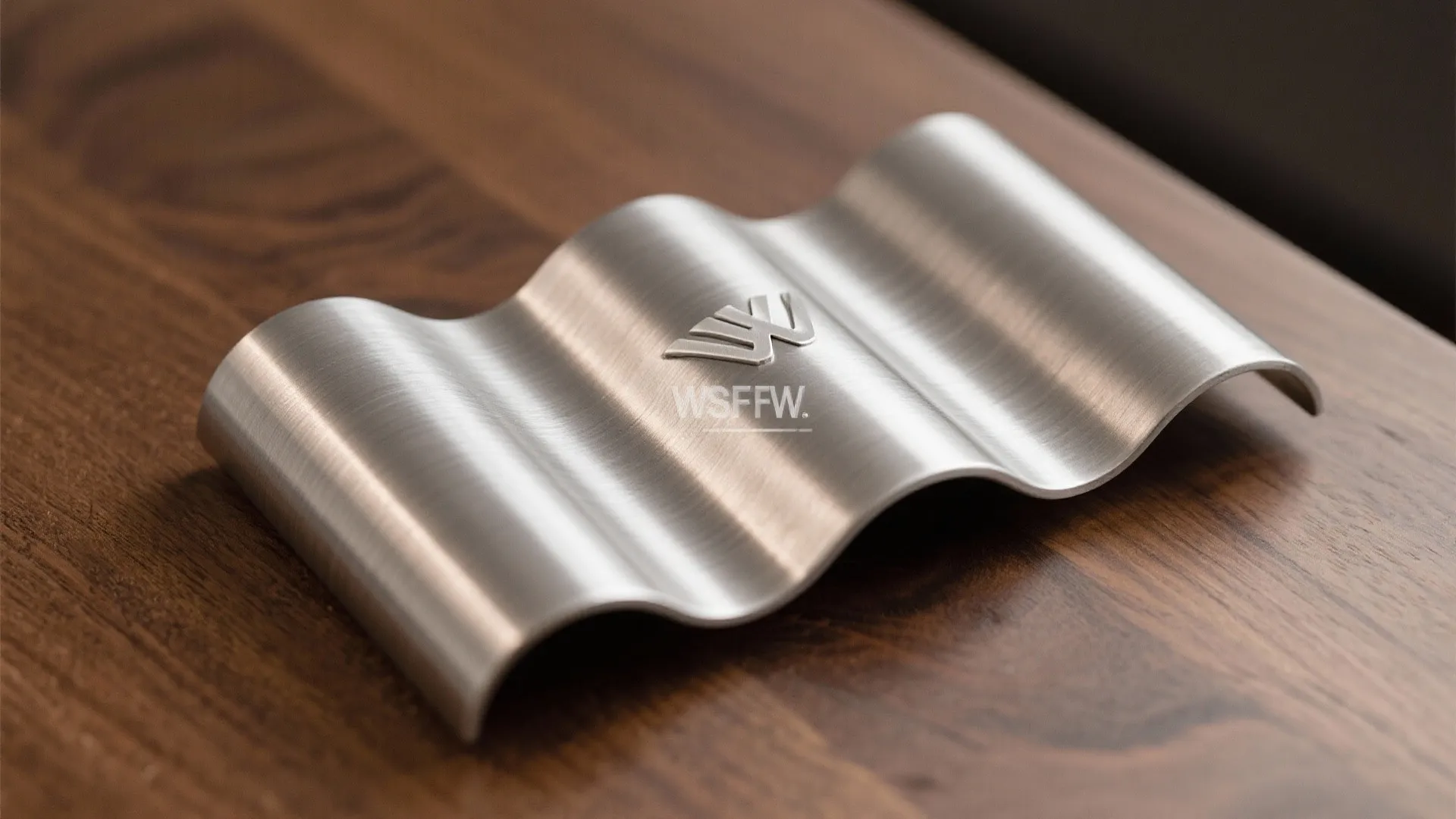 Close up view of a wavy silver metal accessory placed on a dark wood table