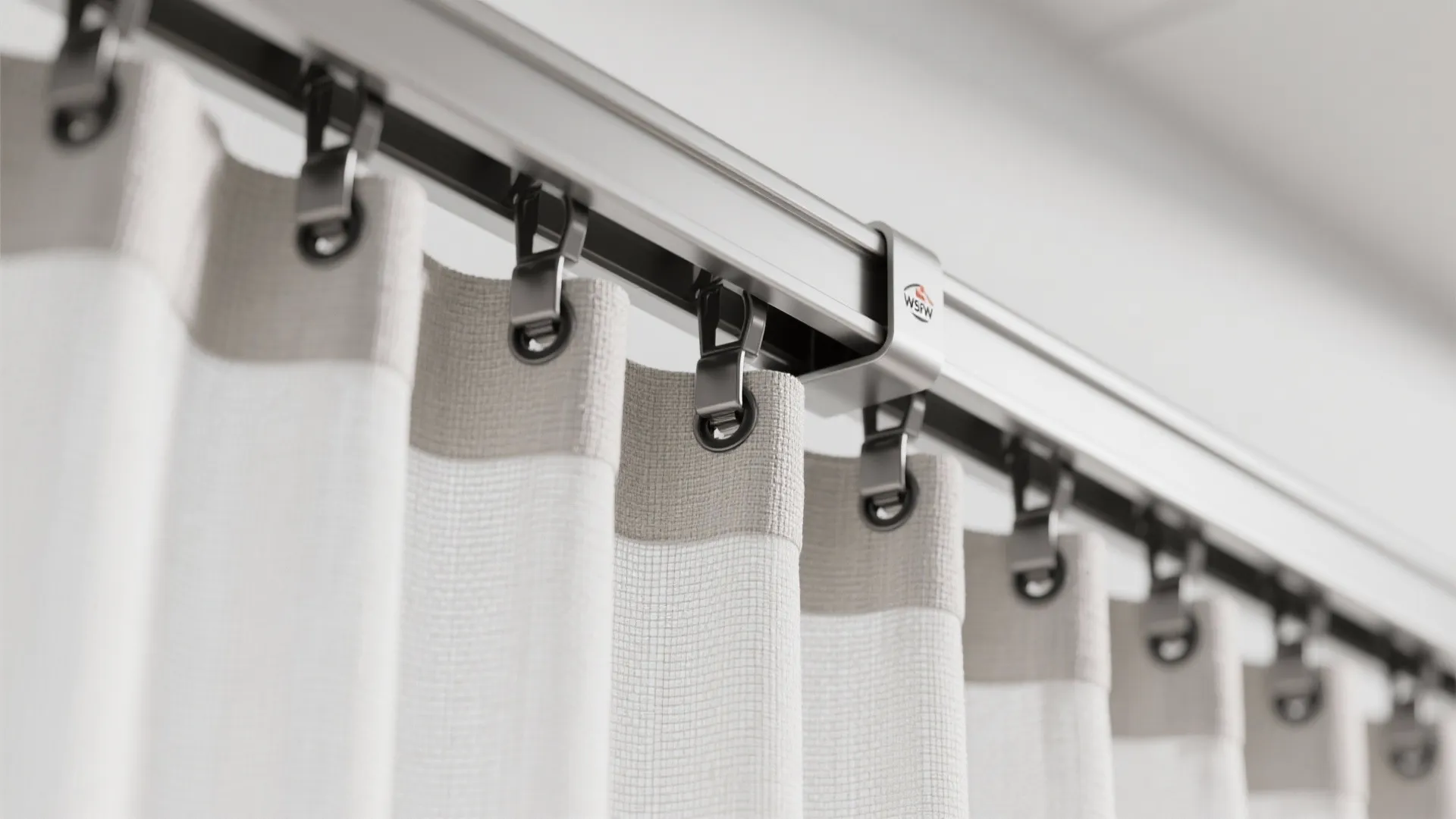 Close up of white fabric curtain hanging on a metal track system in bright room