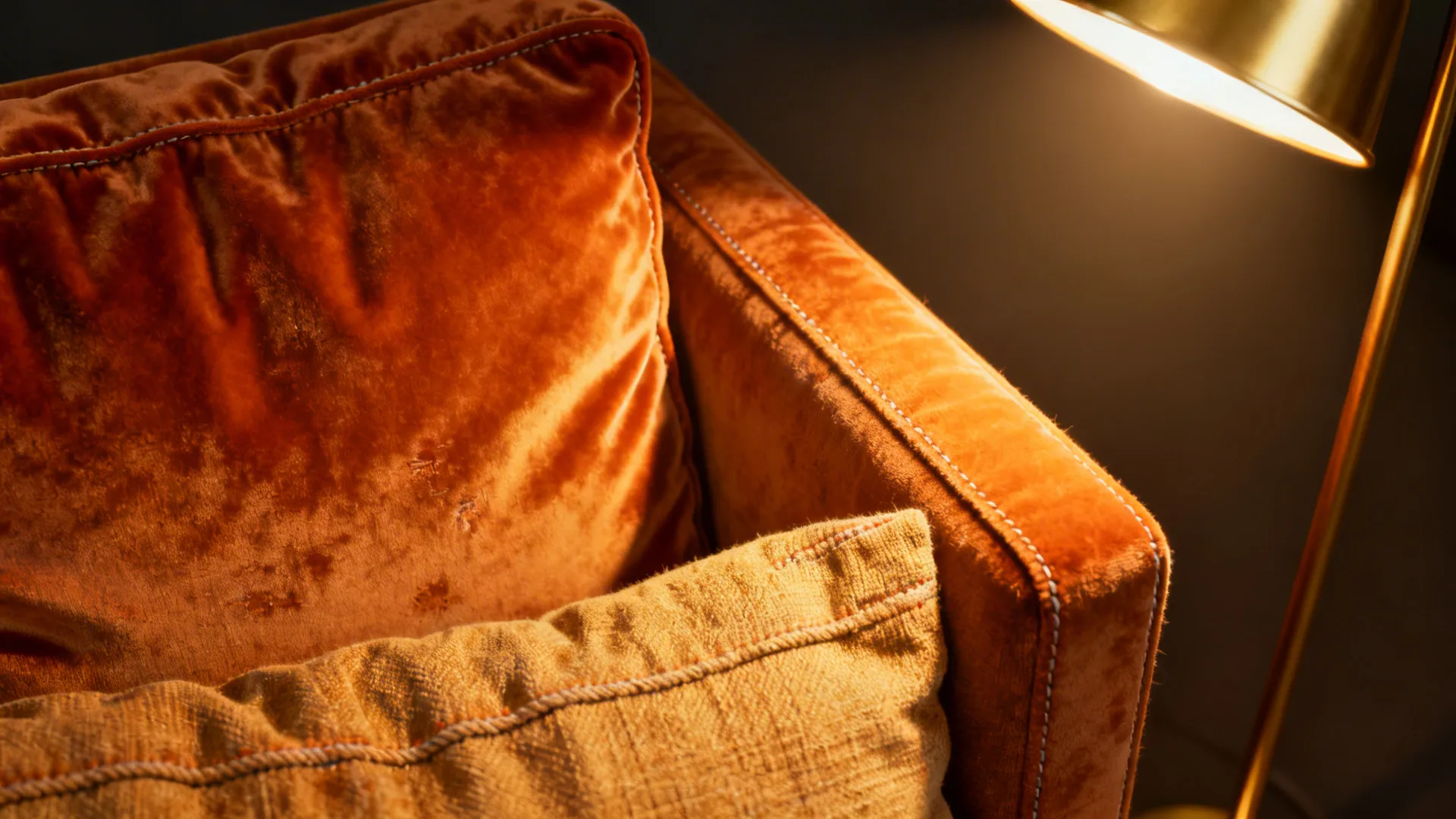 Close-up of burnt orange fabric textures highlighted by directional lighting.