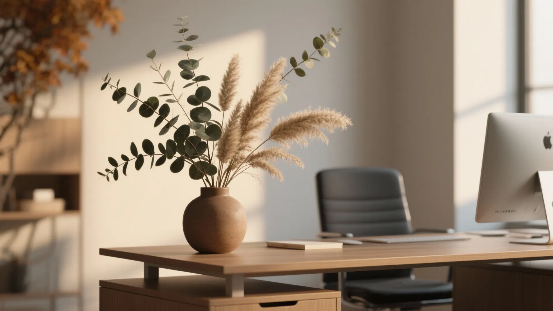 Modern office desk with wooden top computer monitor black leather chair and brown flower vase