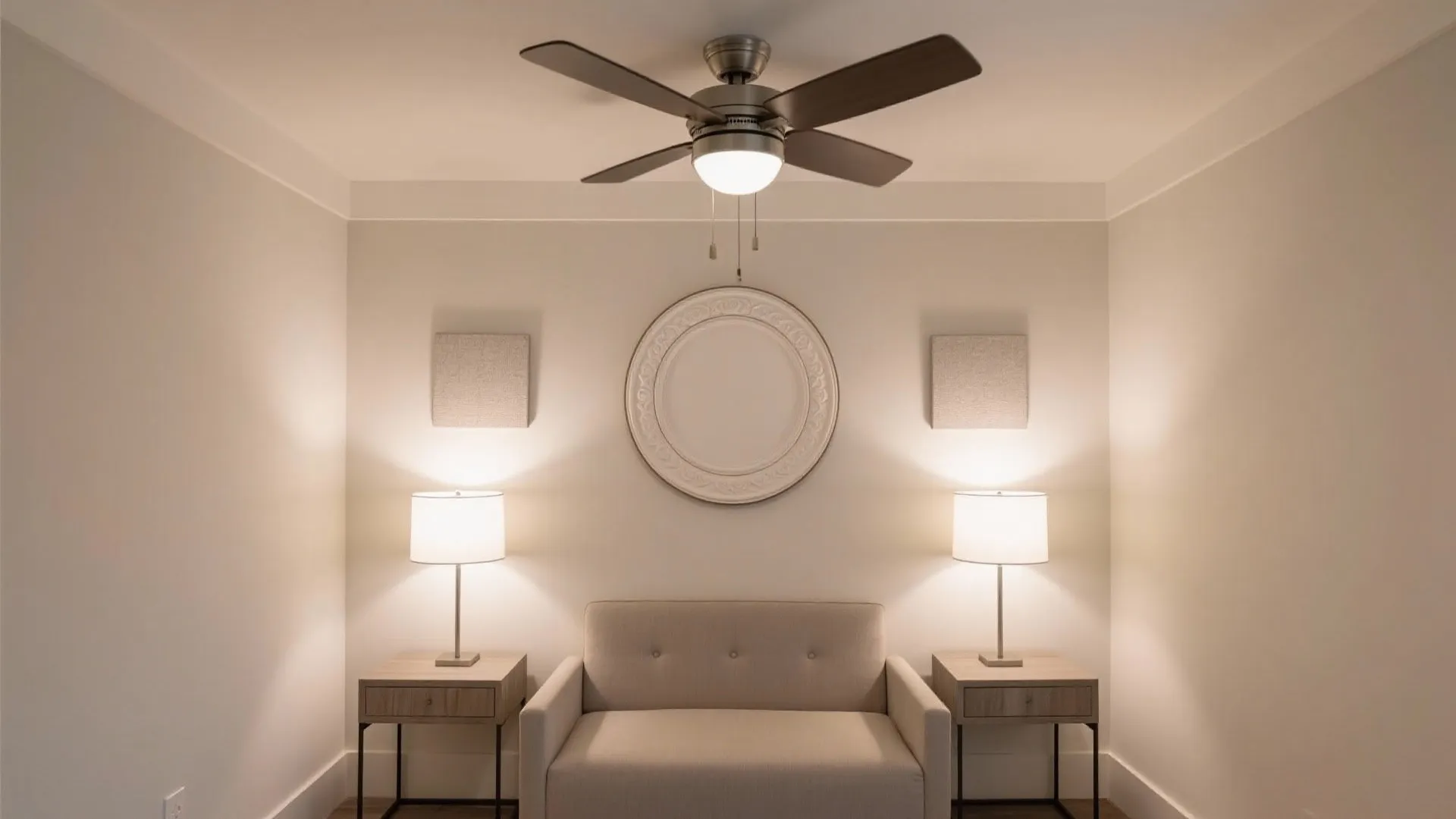 Symmetrical room with beige sofa two table lamps a ceiling fan and round wall design
