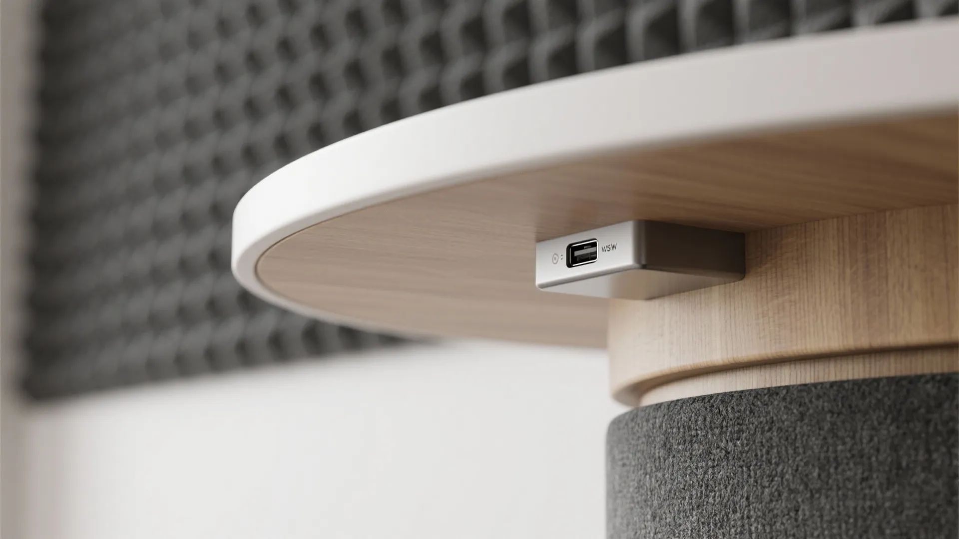 Close-up of small silver USB charging port installed under the edge of a wooden table