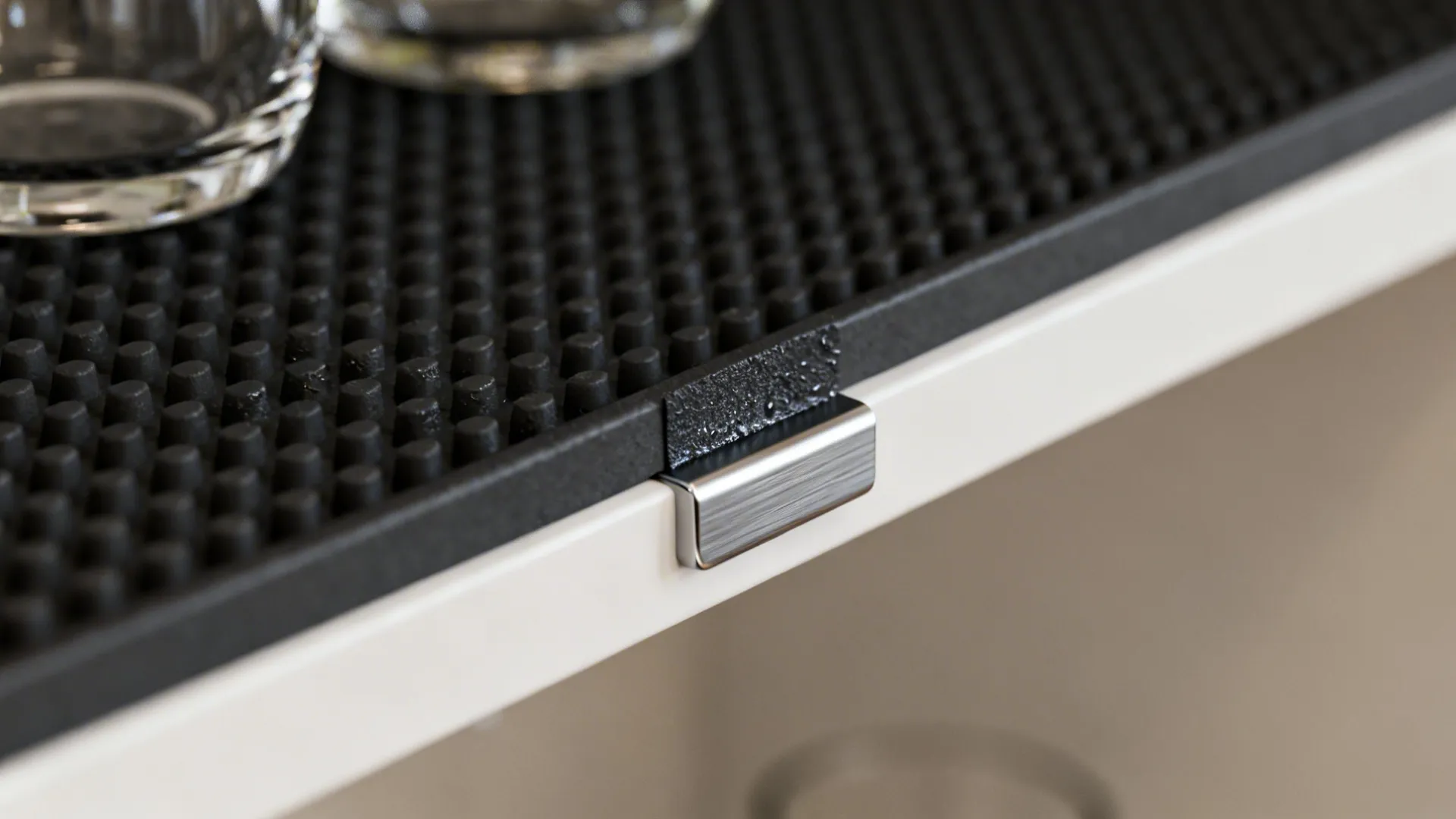 Macro detail of rubber shelf liner, adhesive non-slip pad and a shelf lip to secure glassware.