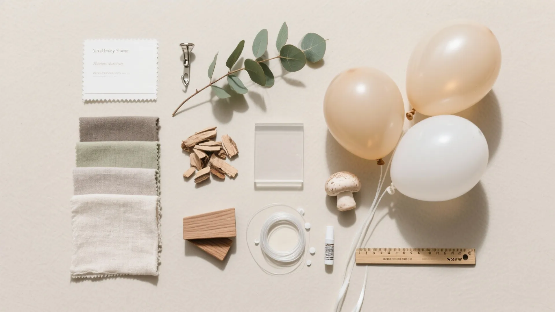 Flat lay of party planning materials including fabric swatches balloons leaves and a wooden ruler