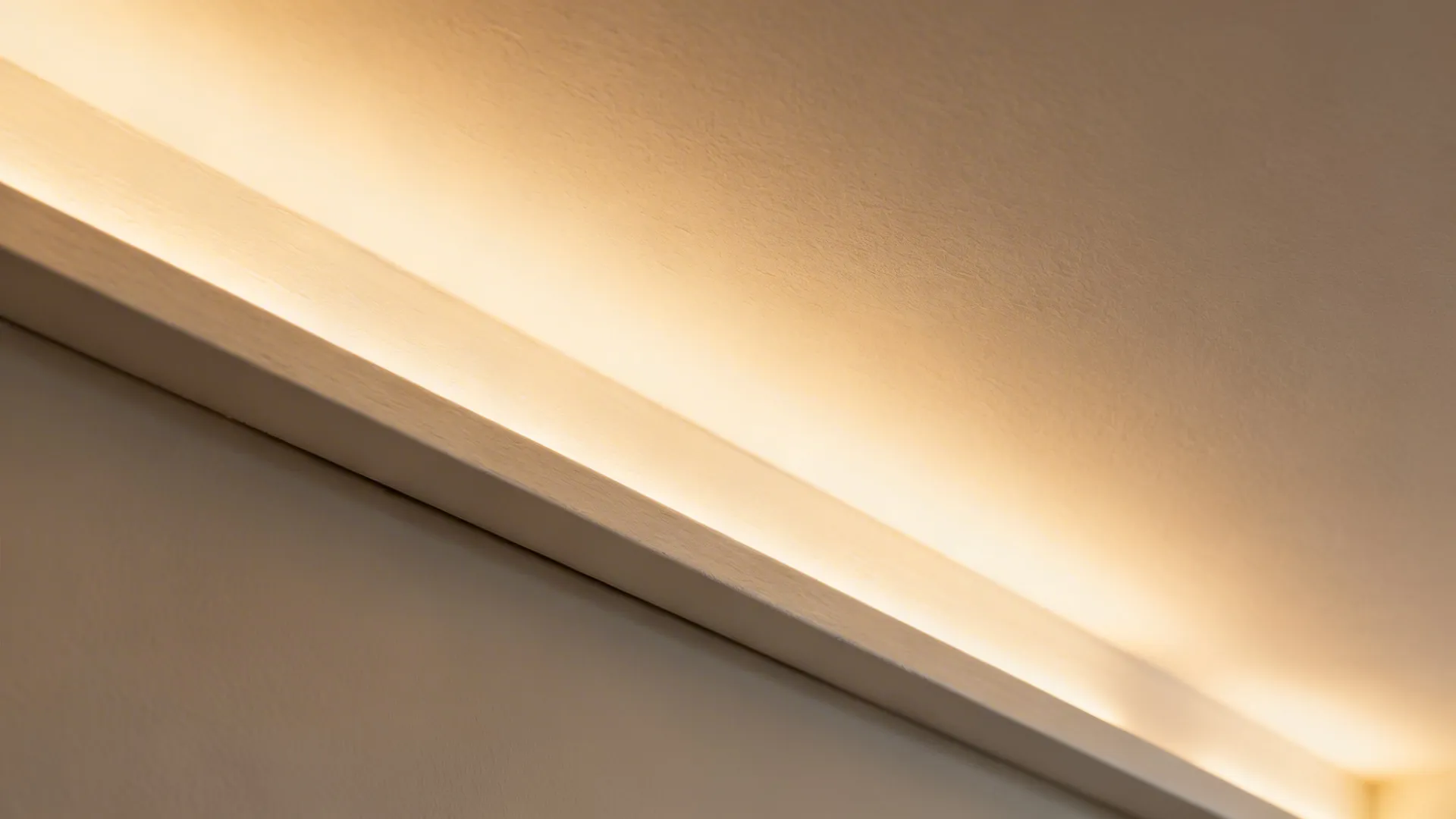 Close up of a warm light strip hidden in a ceiling corner for soft room lighting