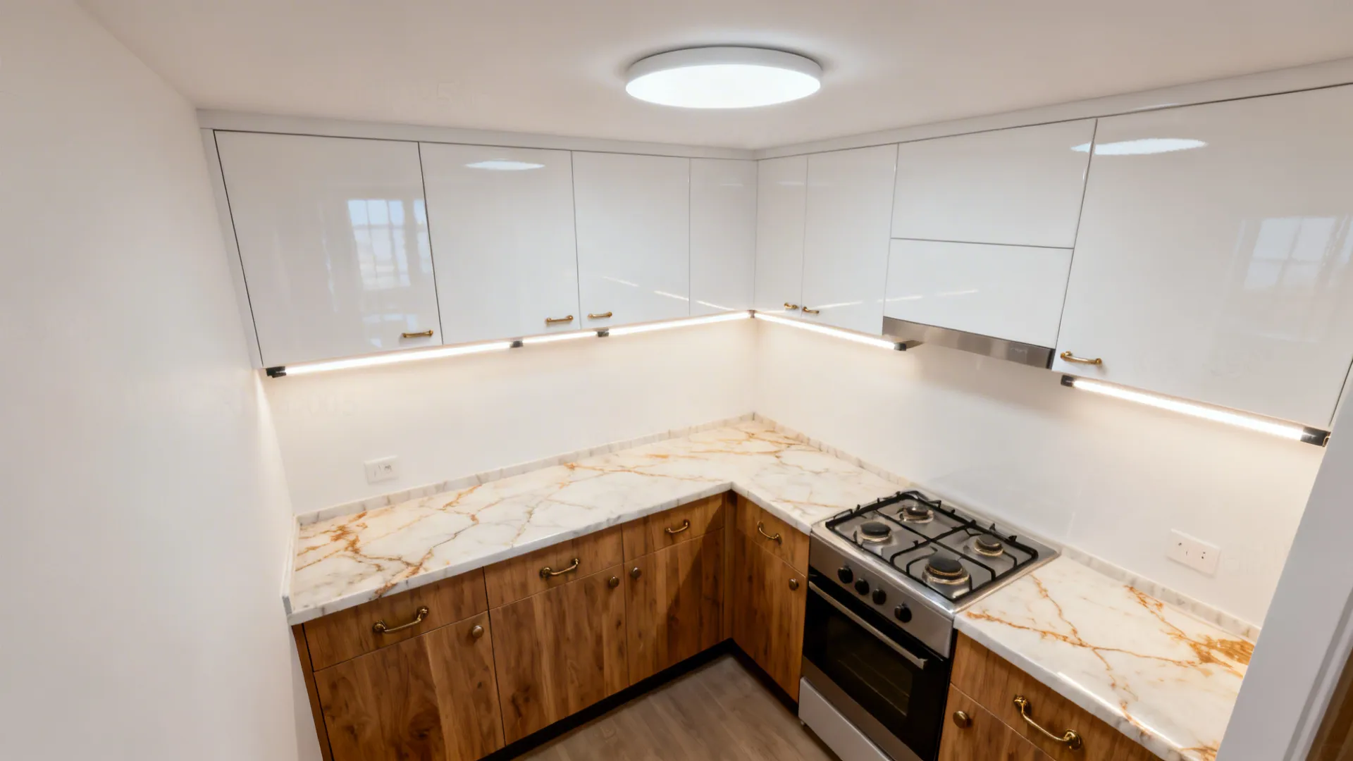 Top-down overview of a small white kitchen showing lighting, two-tone cabinets, and warm-veined counters.