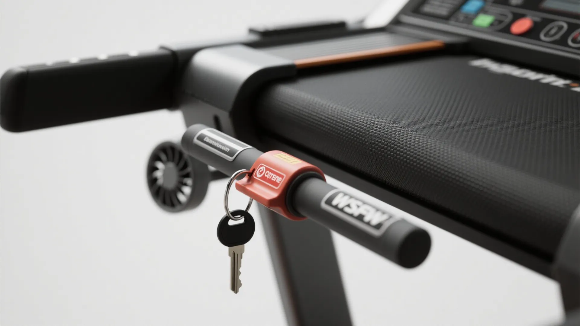 Close up view of a treadmill safety key with red clip and small metal house key