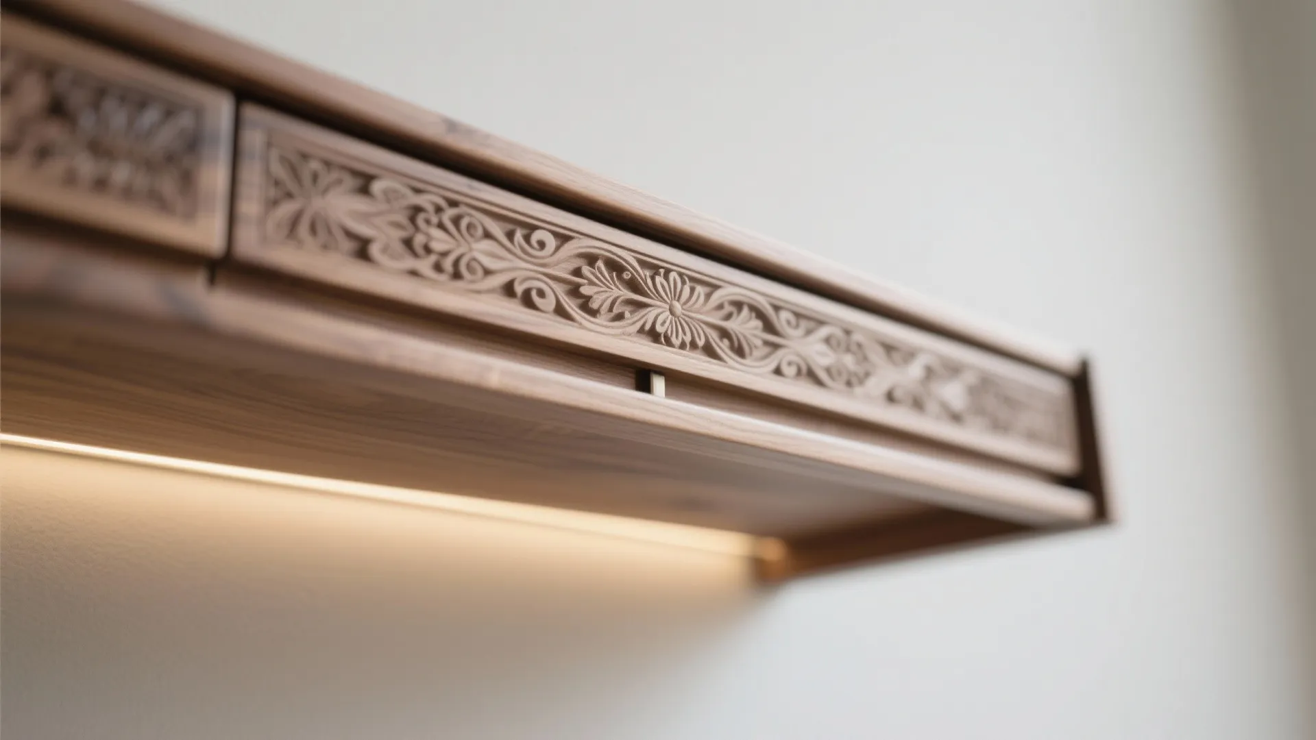 Detailed view of a dark wooden cabinet drawer featuring flower patterns and warm hidden light fixture