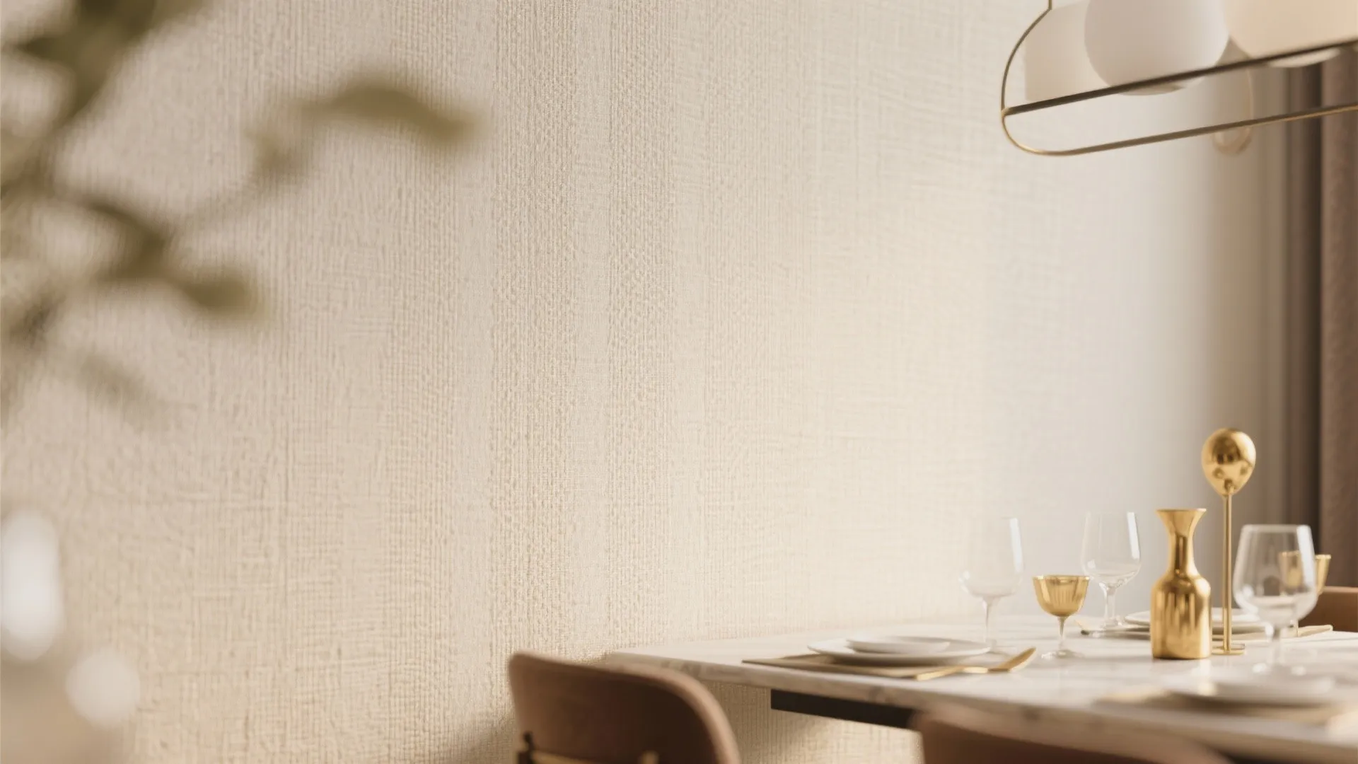Close up of beige textured wall in dining room with marble table and gold accessories