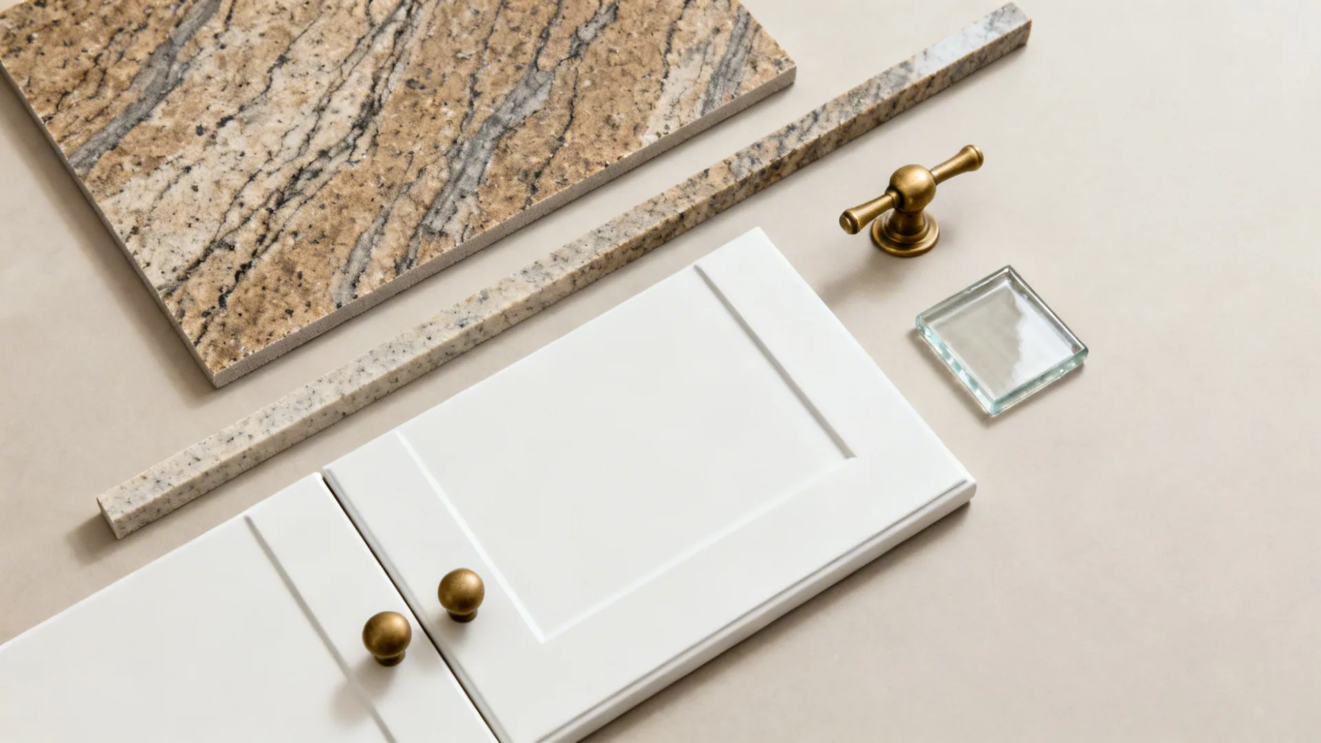 Flat lay with Fantasy Brown Granite, matte white swatch, brass hardware, and glass tile.