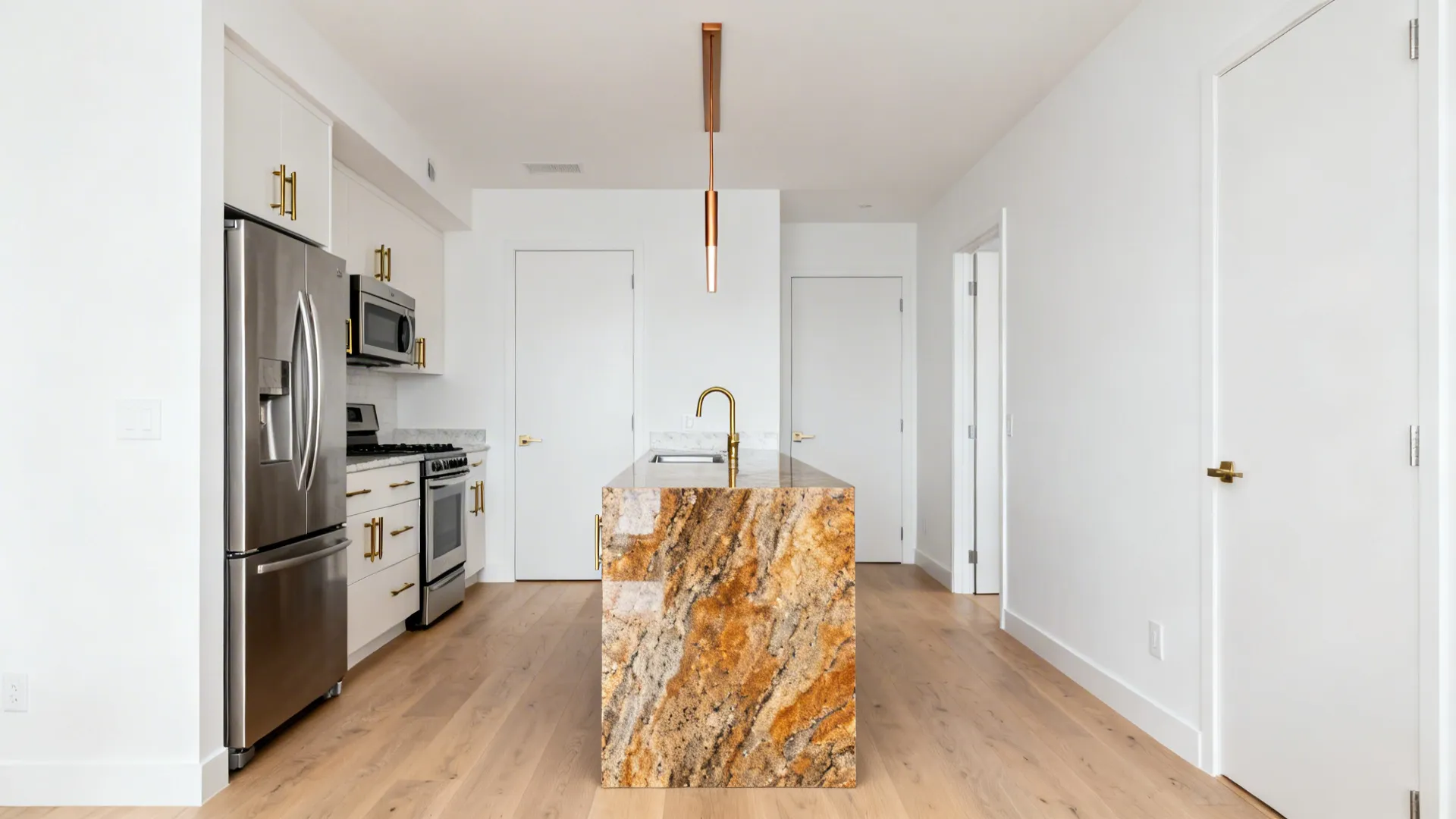 Slender kitchen island with a Fantasy Brown Granite waterfall and brushed brass accents.