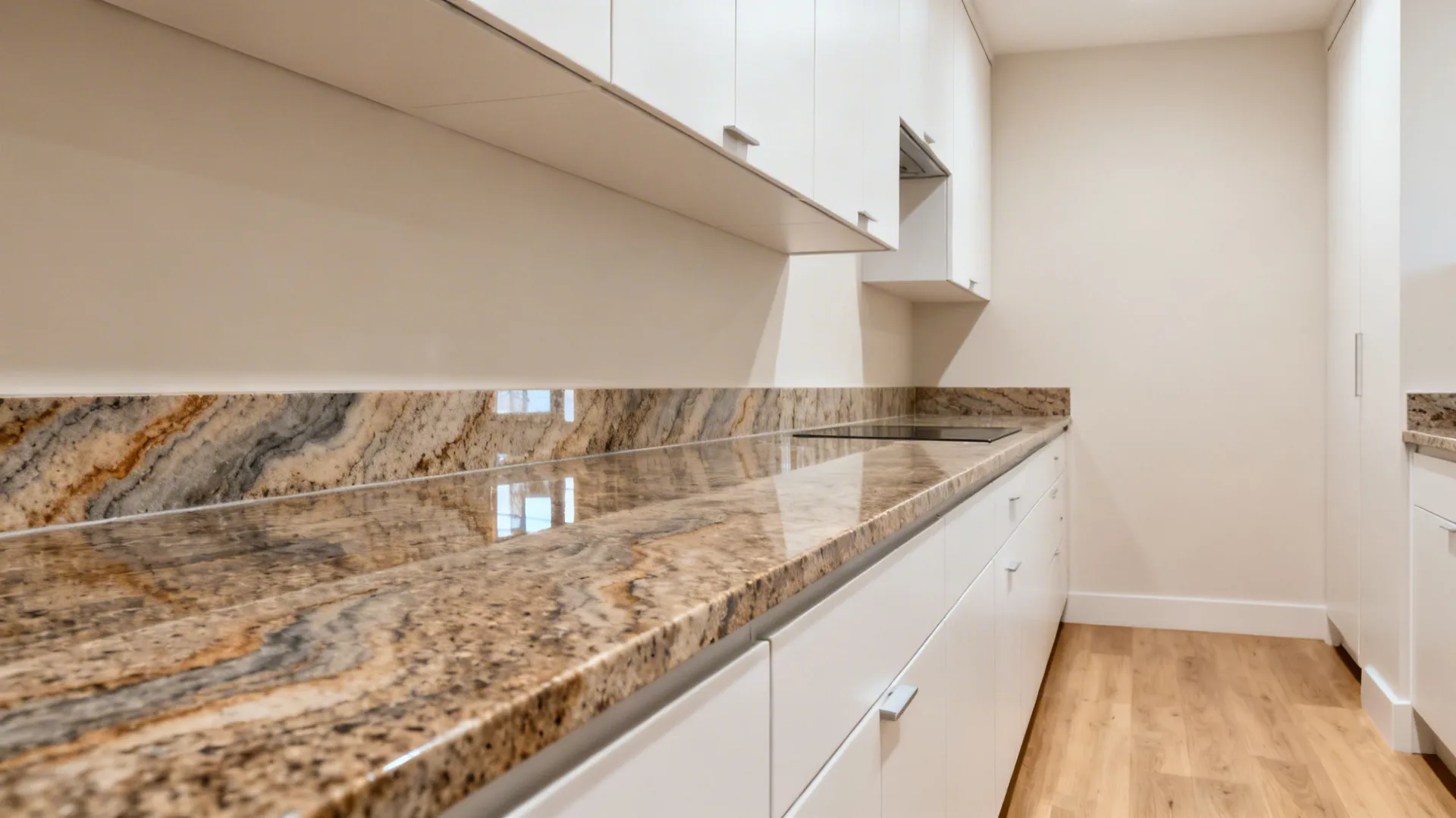 Galley kitchen with Fantasy Brown Granite and matte white slab cabinets that brighten the space.