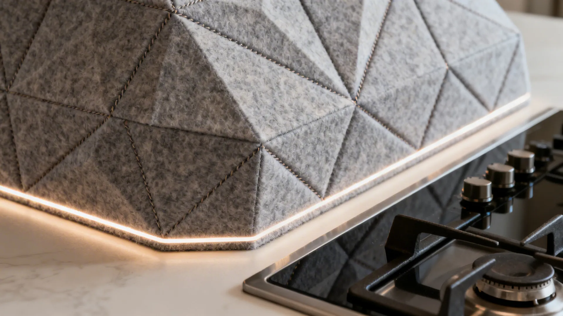 Close-up of a faceted acoustic felt range hood with crisp seams and texture.
