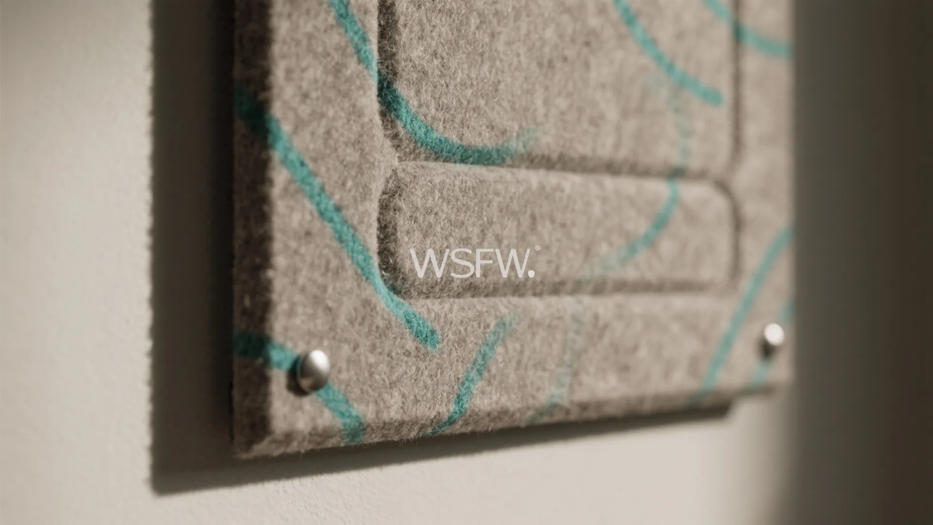 Close up of grey felt wall panel with blue line patterns and silver metal nail detail