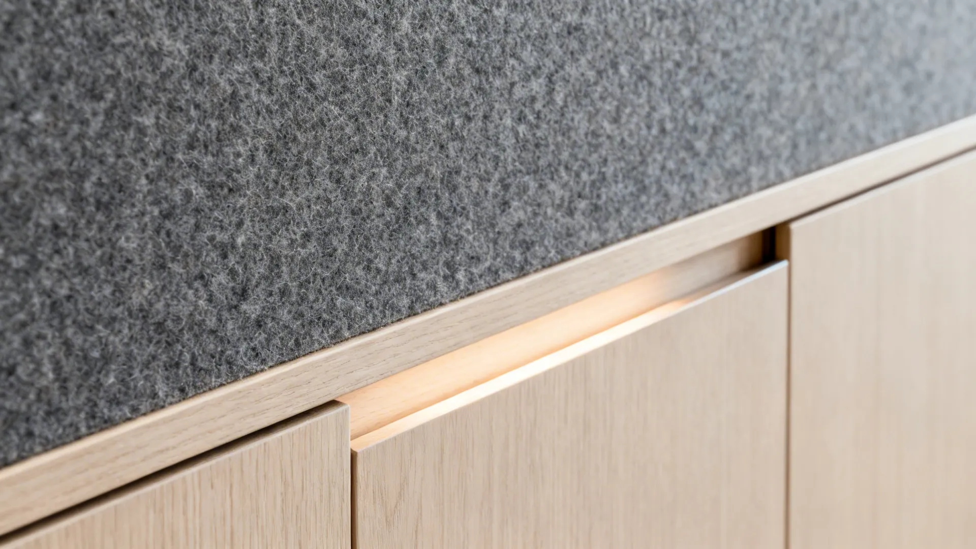 Macro of felt pinboard texture beside a matte pale wood credenza with soft LED light.