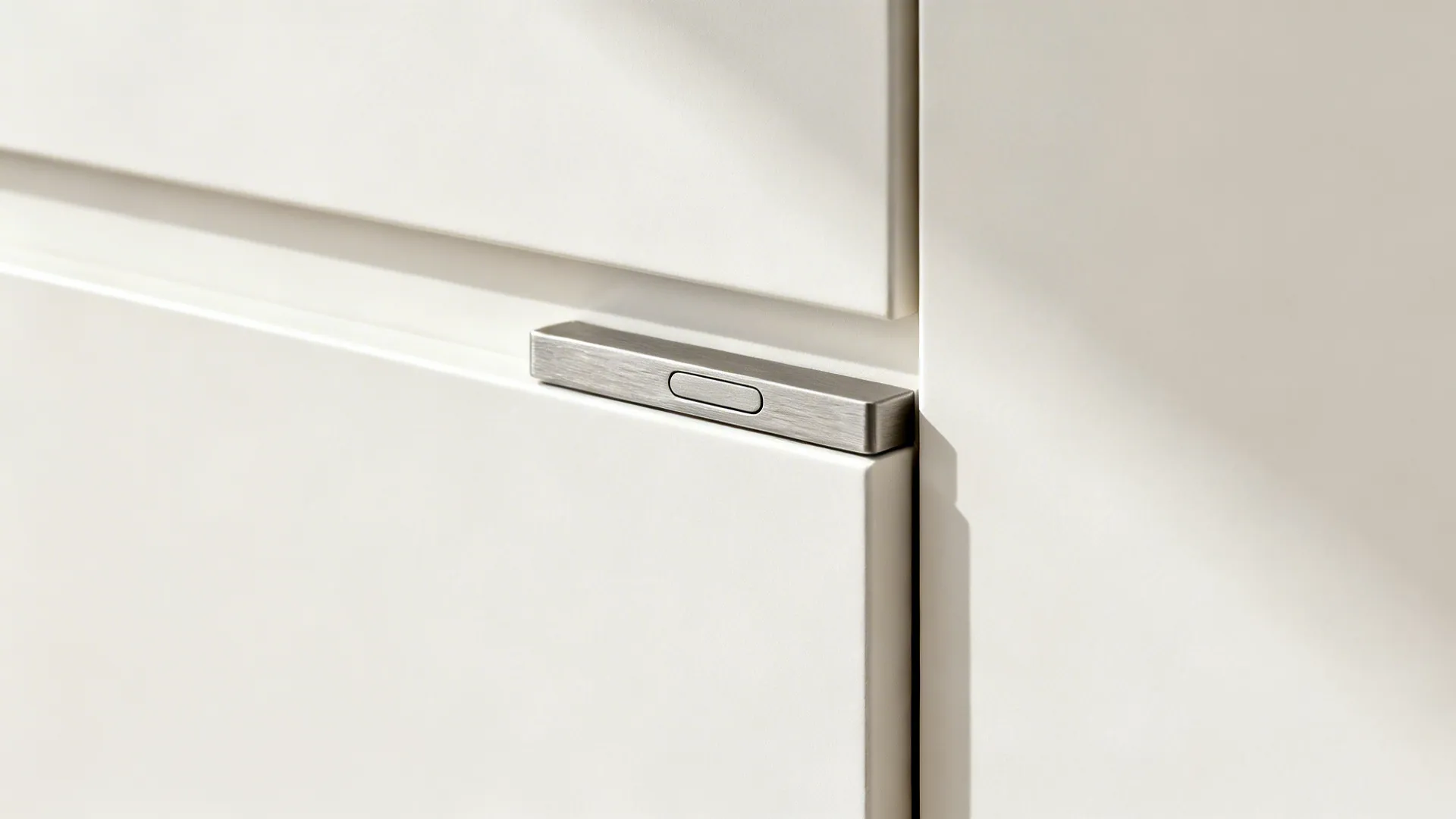 Macro view of a matte-white cabinet with a slim finger pull and crisp edges.
