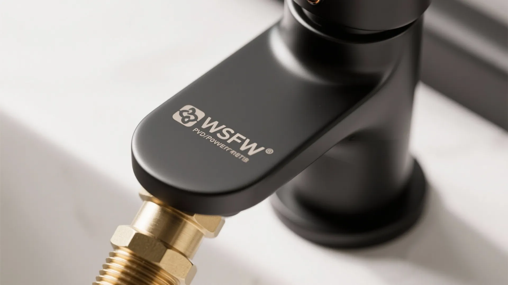 Close up of a matte black water tap with brand logo and brass connector part