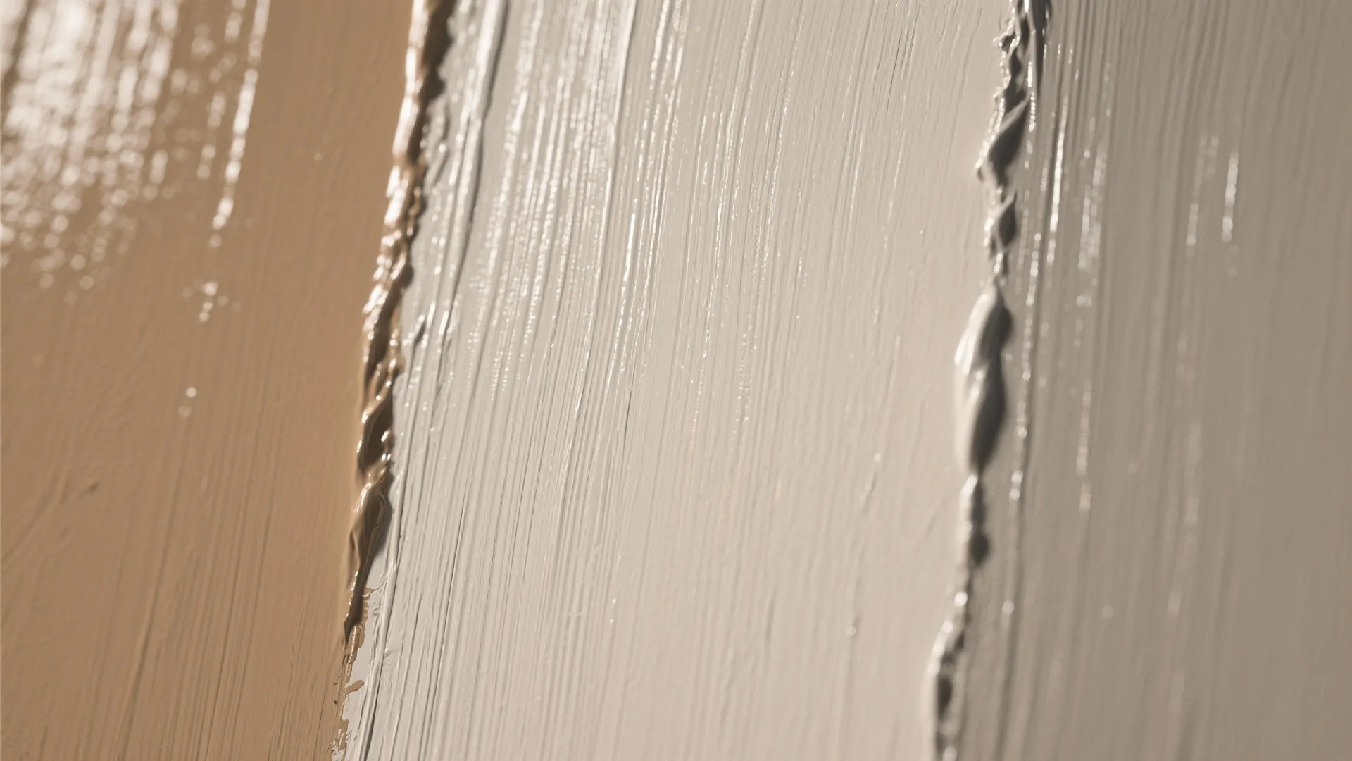 Close up view of wet beige and brown paint texture with visible vertical brush strokes
