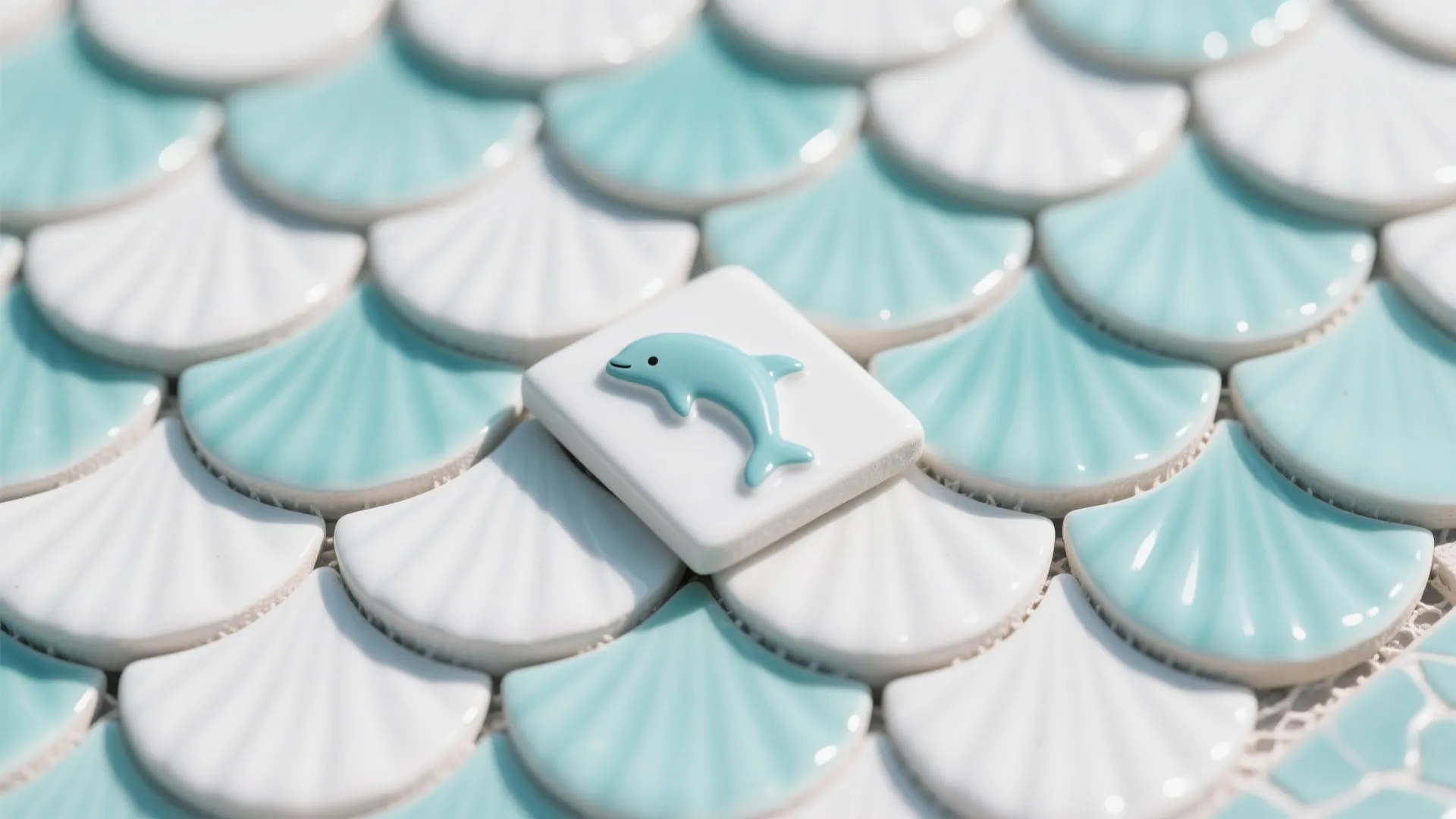 White and light blue fan shaped wall tiles featuring a small blue dolphin on top