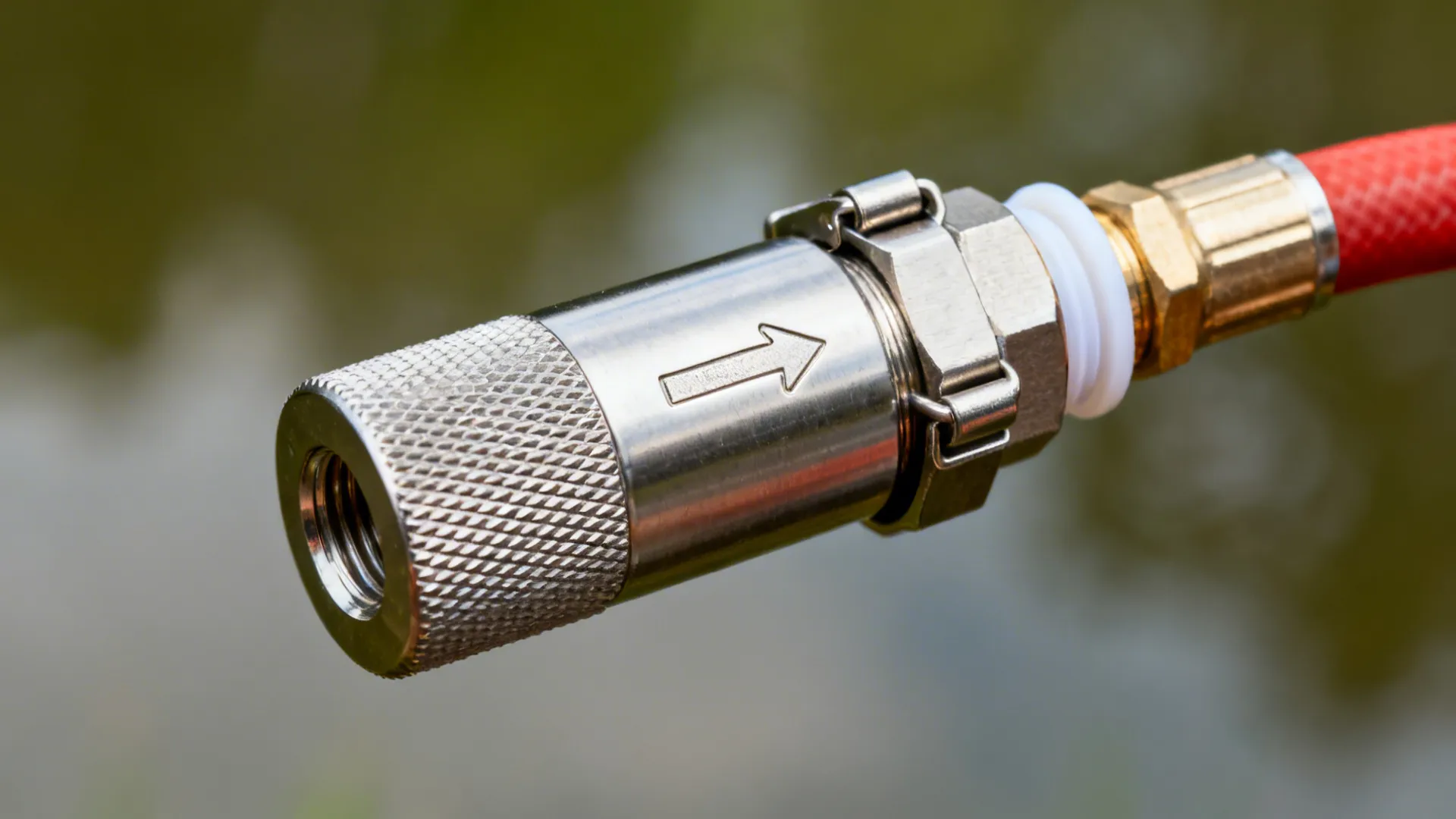 Macro of an inline flame arrestor attached to a biogas hose with a secure clamp.