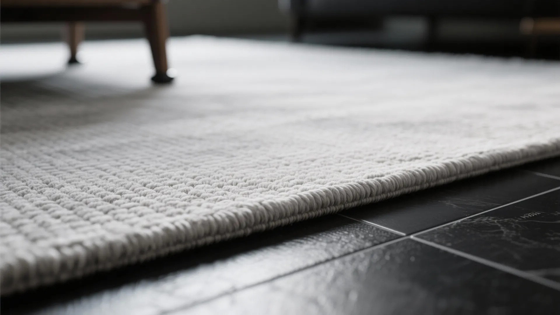 1. Layer a light grey flatweave over black tile