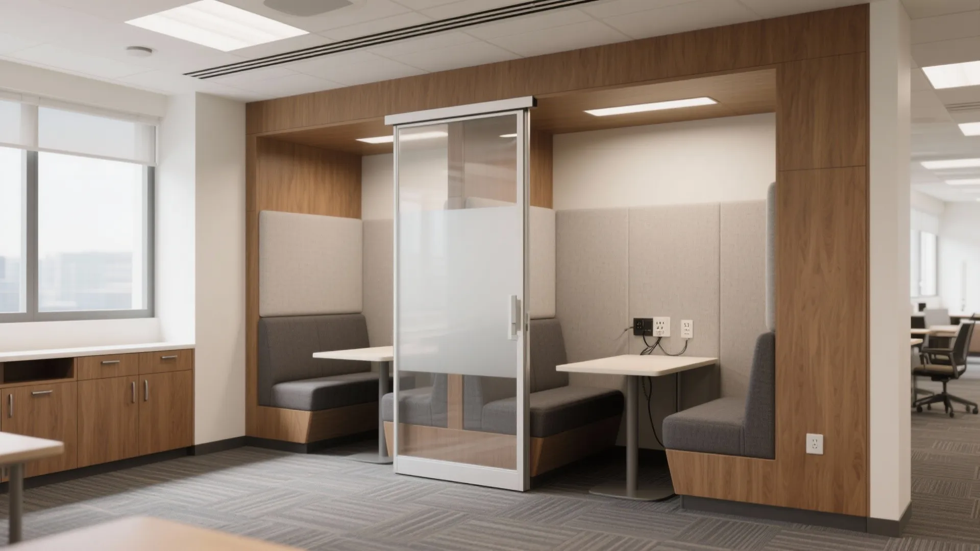 Private office meeting booth with grey sofa seating small white tables and glass sliding door