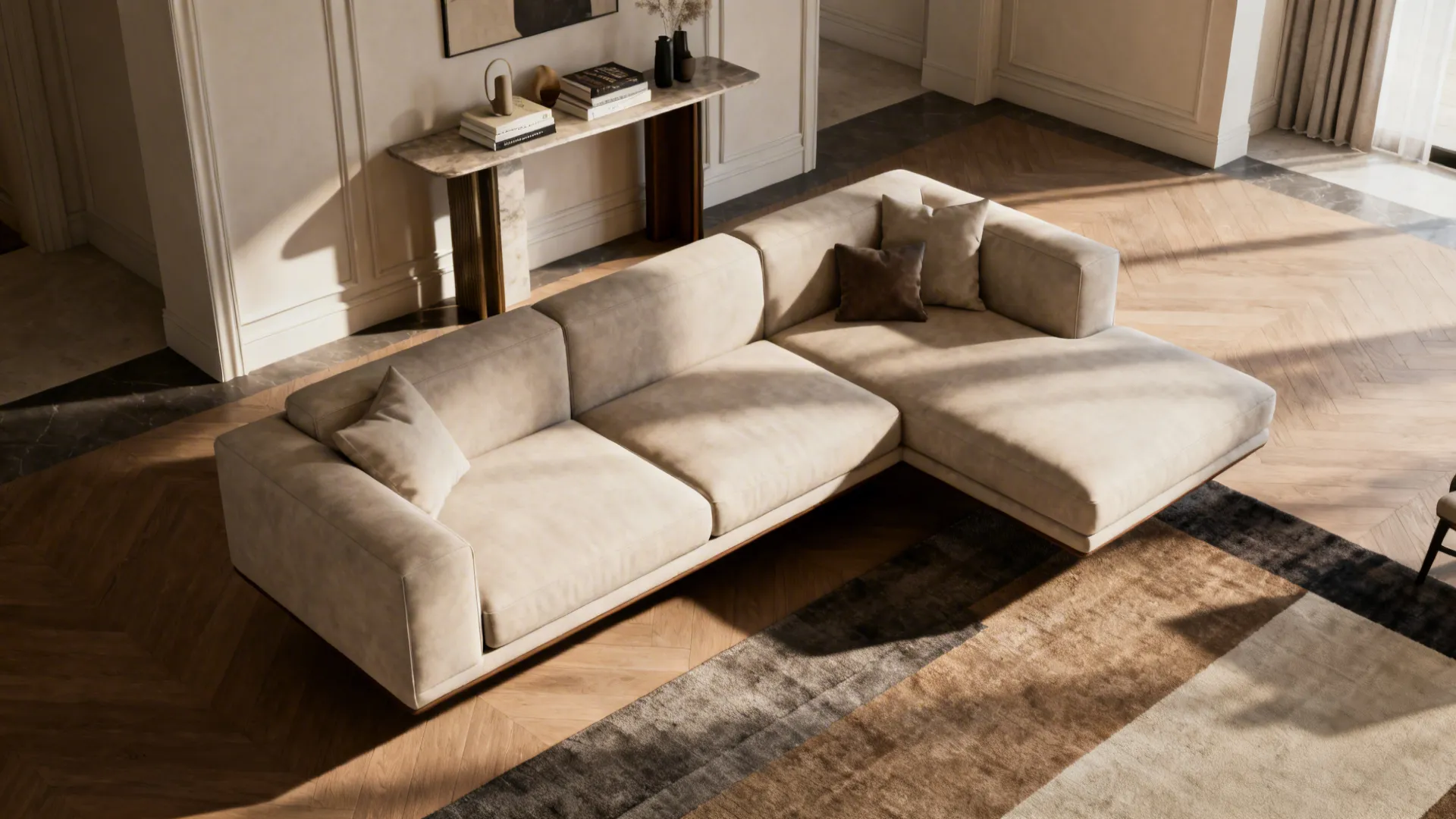 Living room with an L-shaped sofa floated from the walls and a console table behind it, creating visual depth.