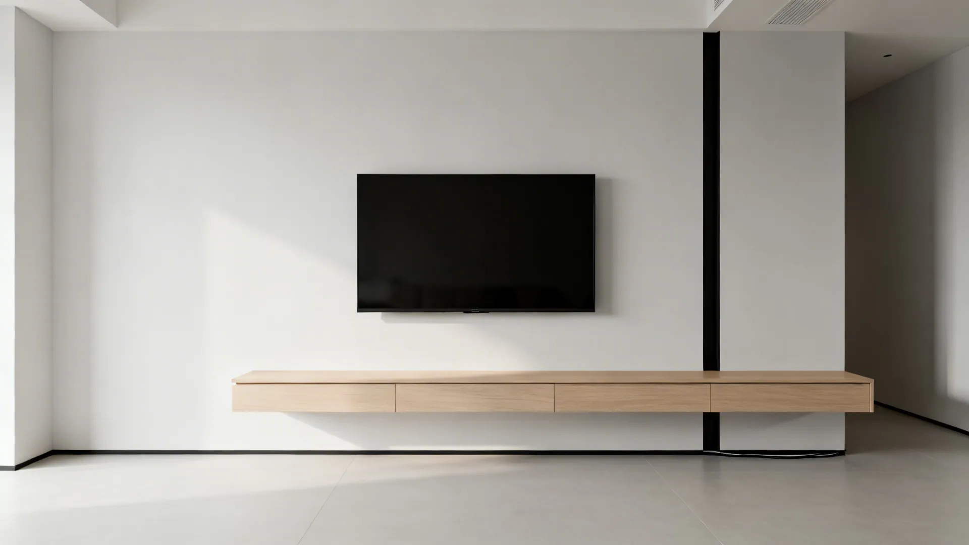 Minimal floating media wall with slim backer panel and hidden cable routing in a compact living room.