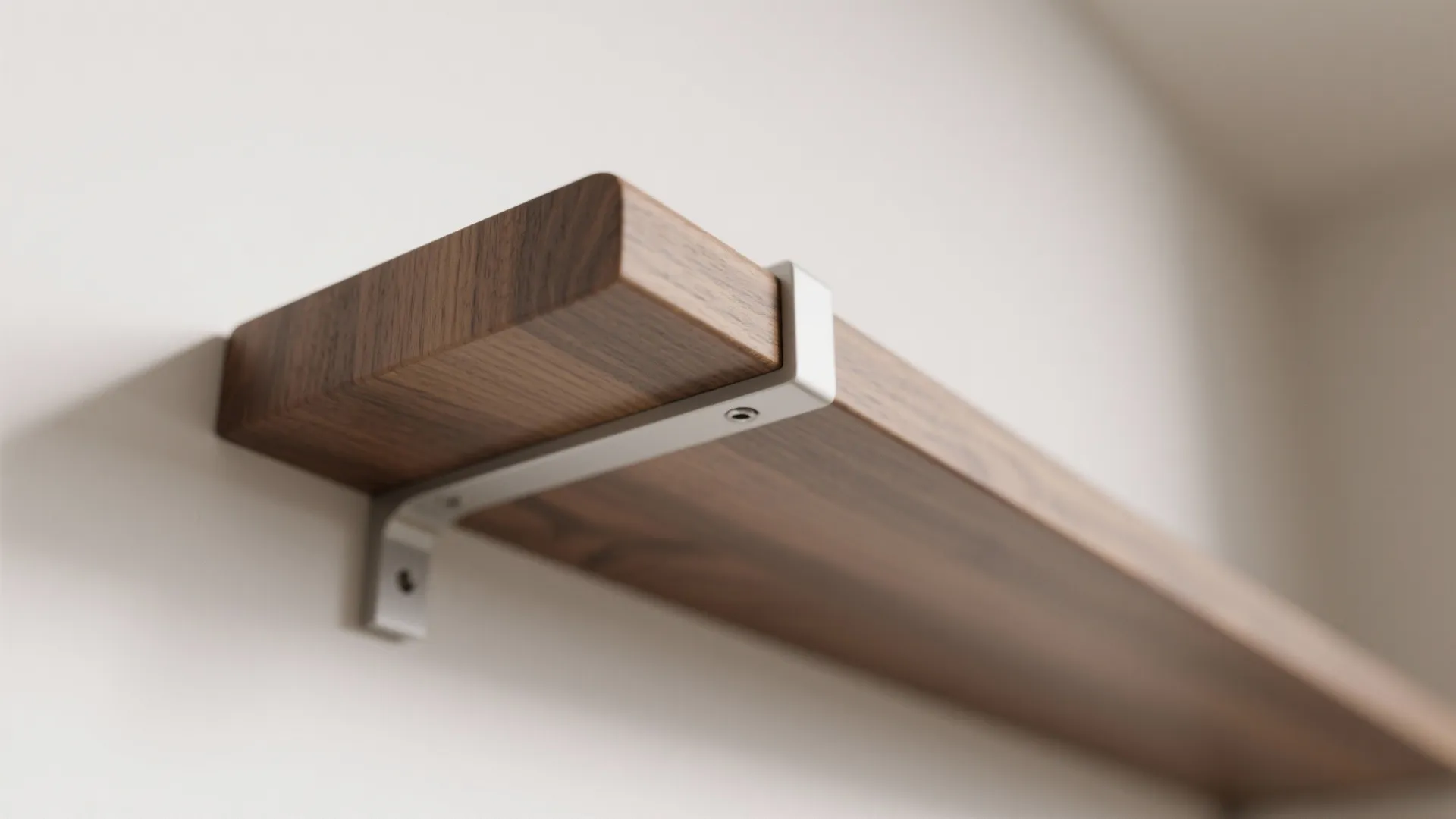 Close-up of slim floating shelf edge and concealed bracket joinery.