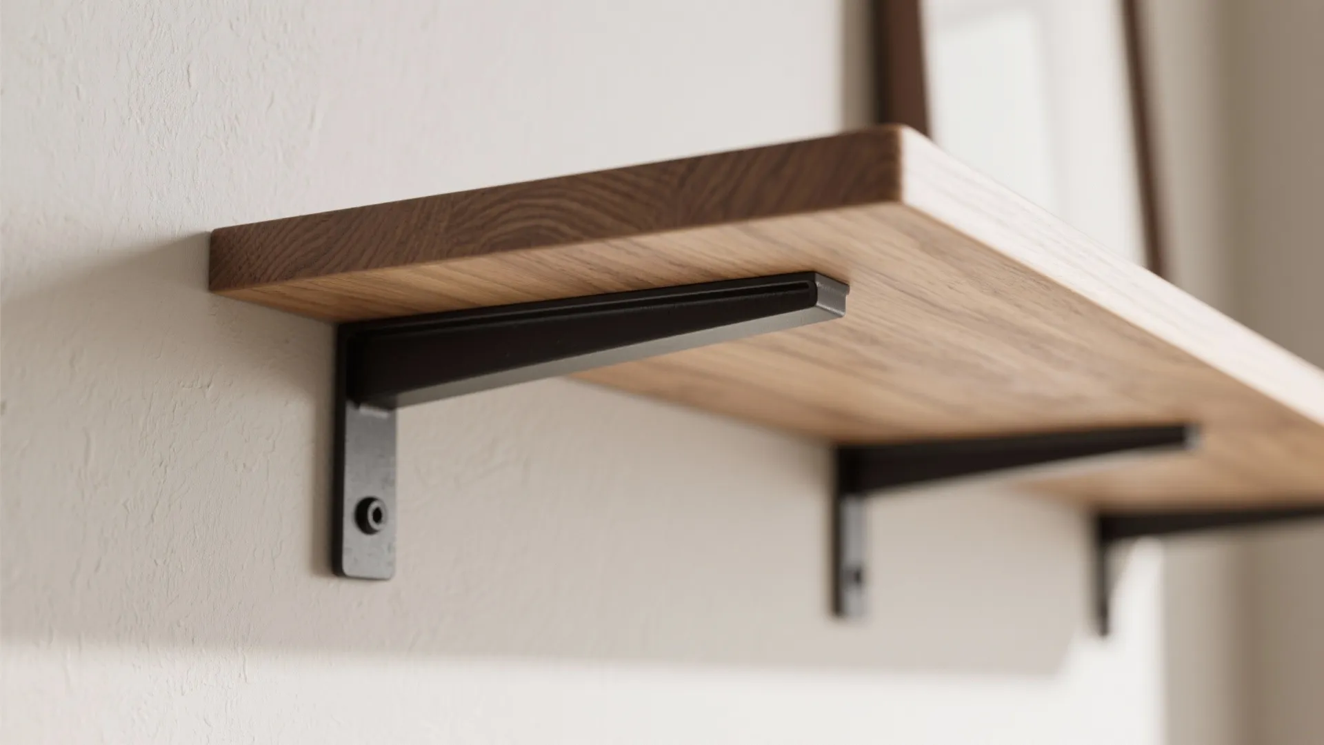 Macro of concealed steel bracket and 1–2 mm shadow gap on a true floating oak shelf.