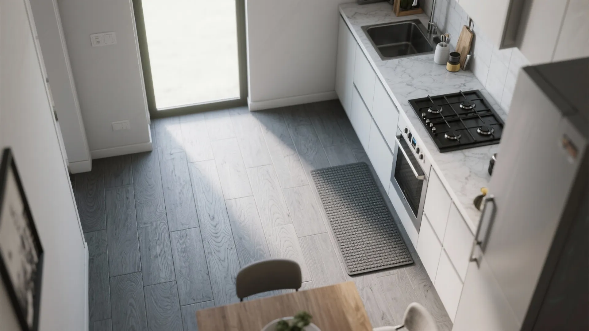 Top view of a white kitchen with grey wood floor and a small grey rug