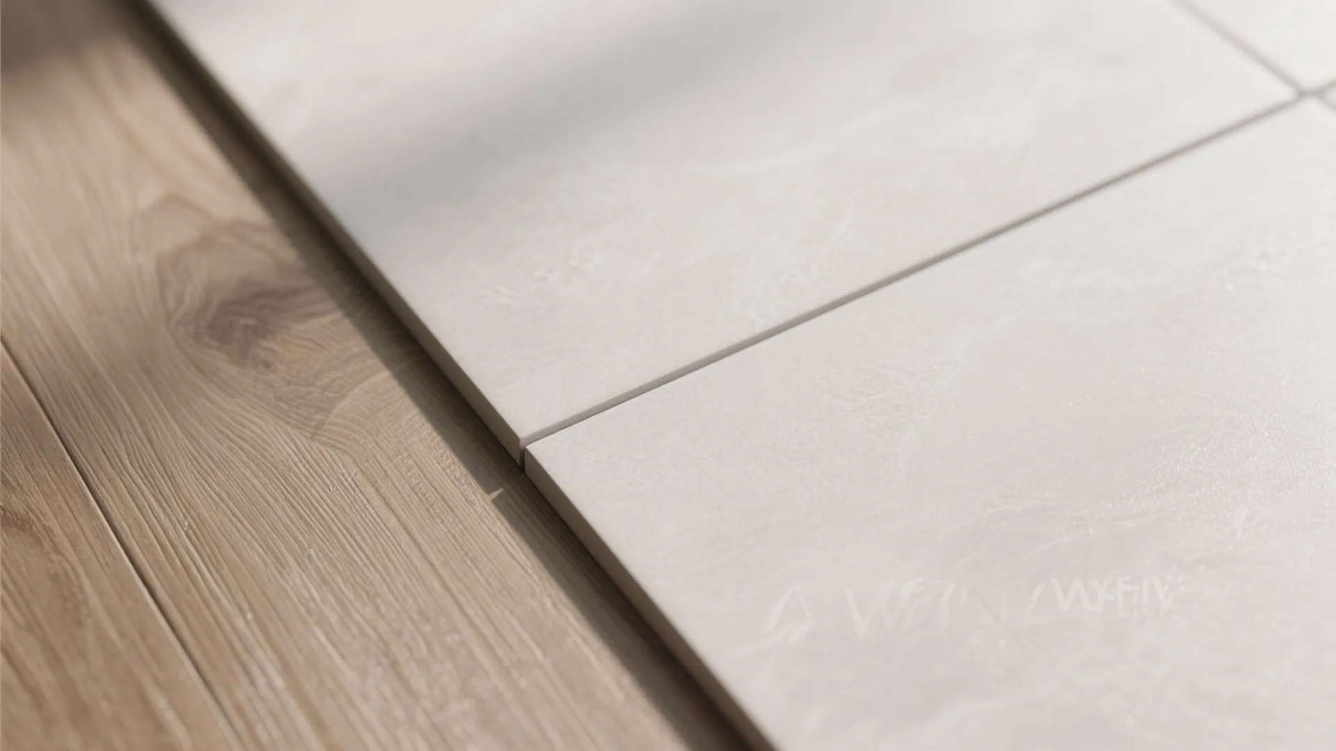 Macro detail of matte vitrified tile with thin grout line transitioning to wood-finish laminate plank.