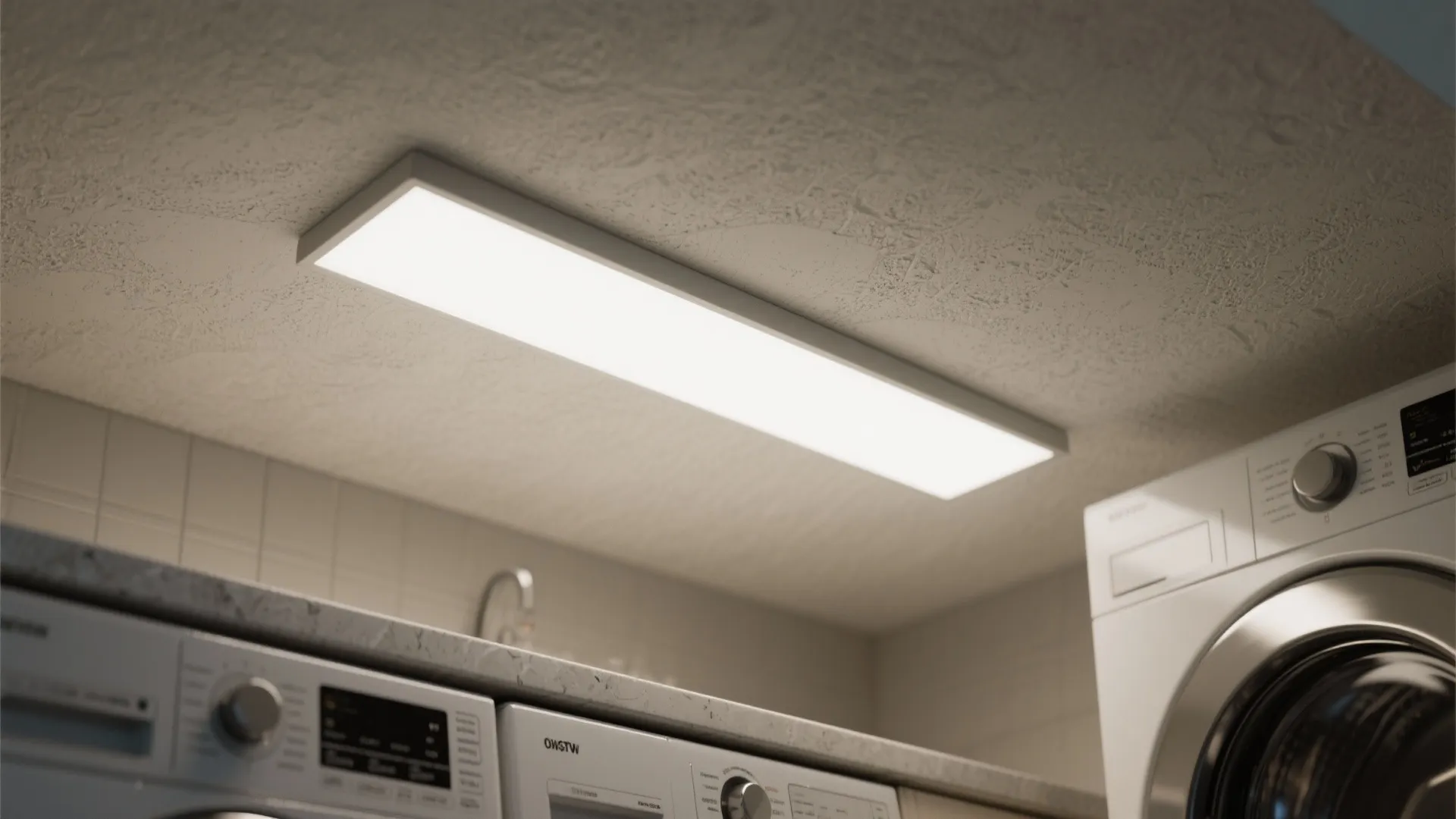 Rectangular white ceiling light panel installed above washing machines in a bright modern laundry room area
