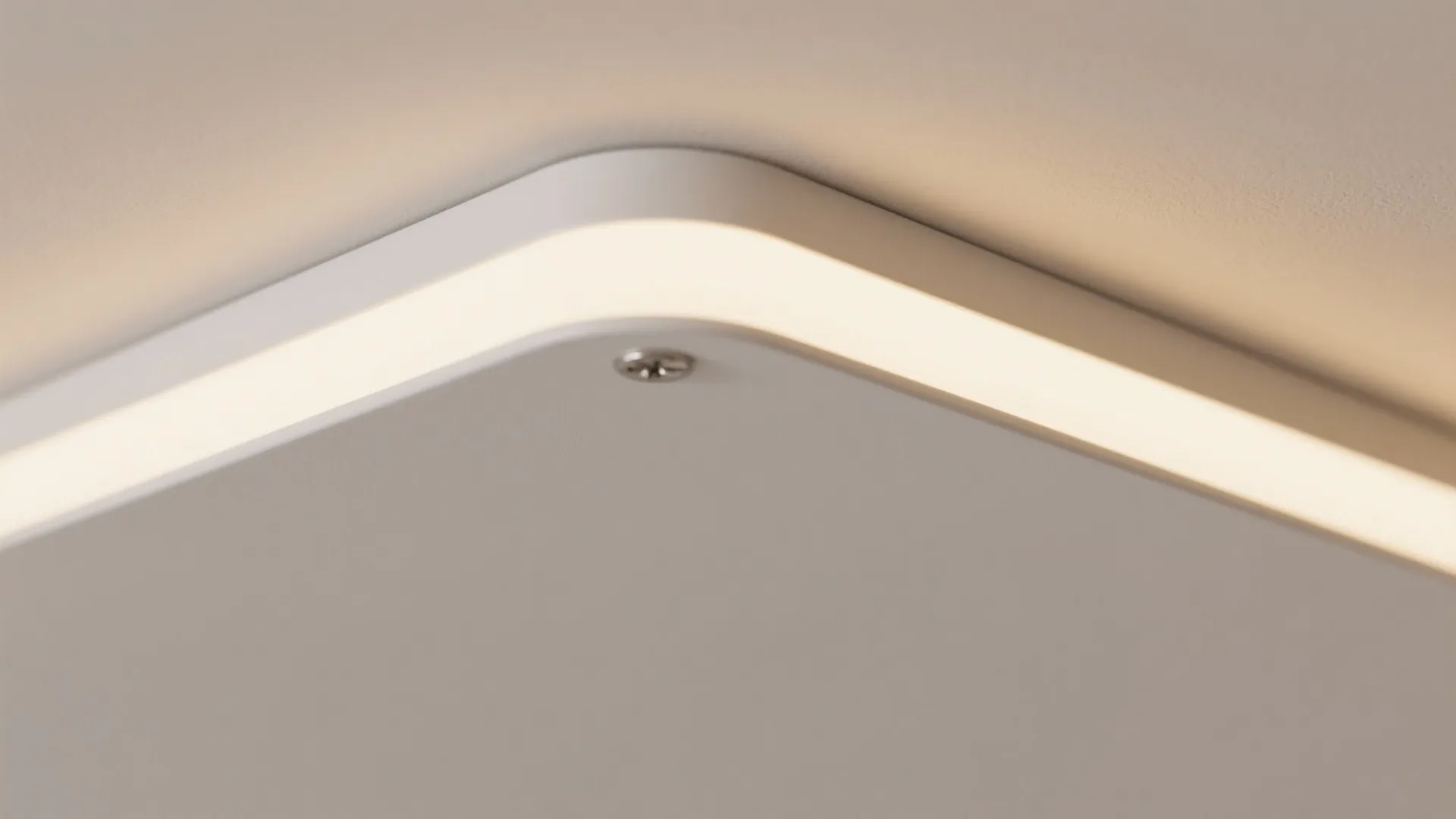 Detail shot of a modern square white ceiling light fixture with rounded corners and glow