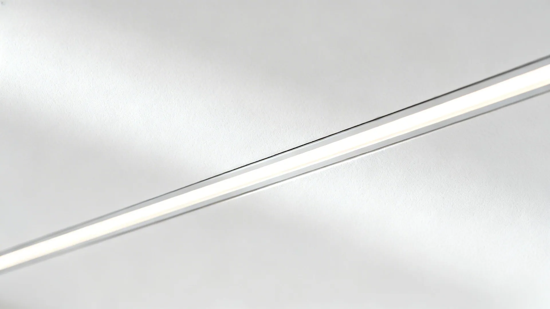 Macro of flush linear light slot and shadow gap in smooth gypsum ceiling.