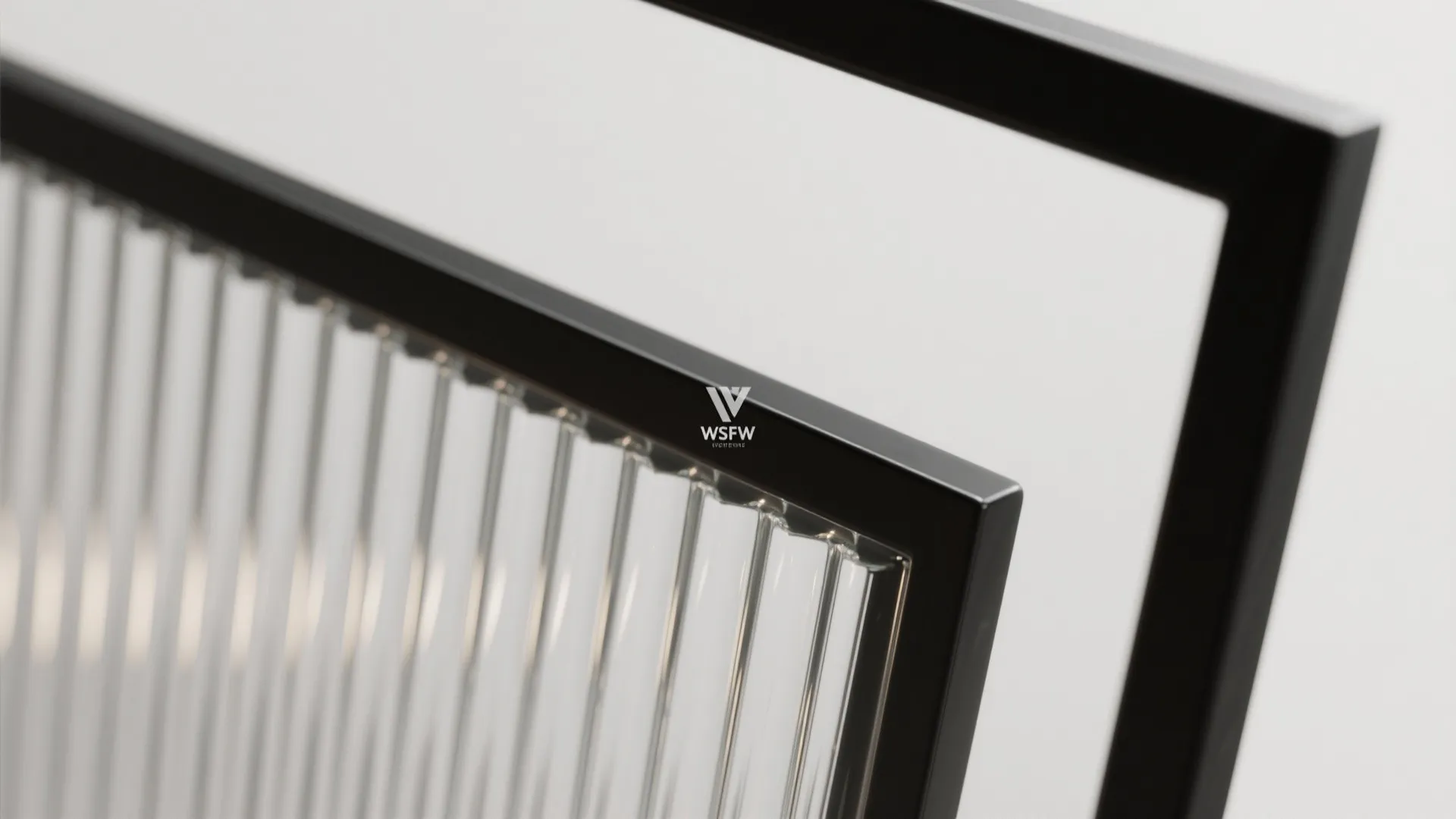 Close-up of fluted glass panel with black metal frame showing texture and clear vertical lines
