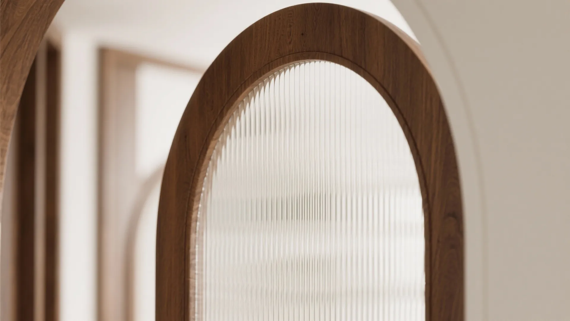 Close up view of wooden arched door with textured glass and white wall in modern home