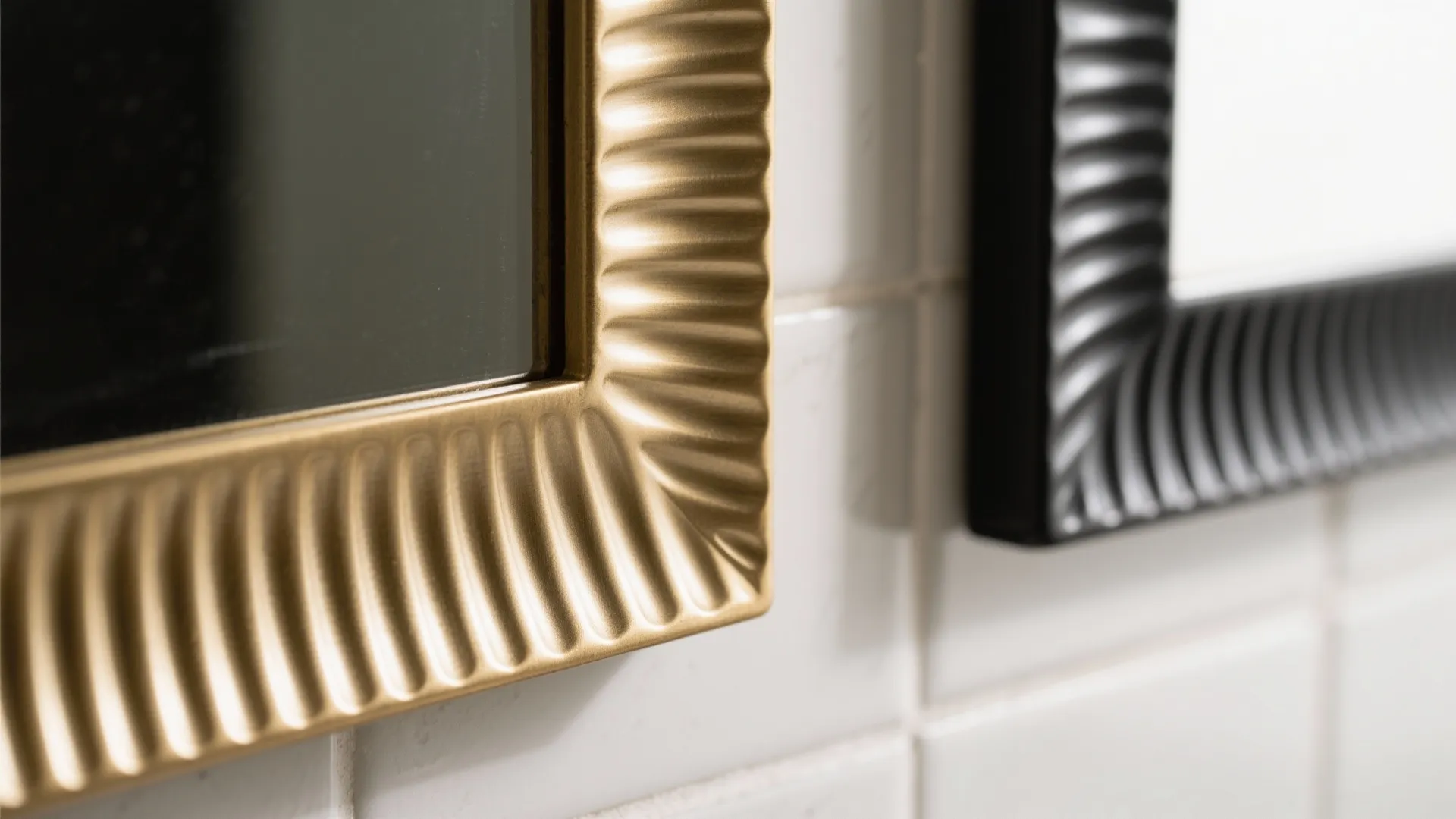 Close up view of gold and black textured mirror frames on a white tiled wall