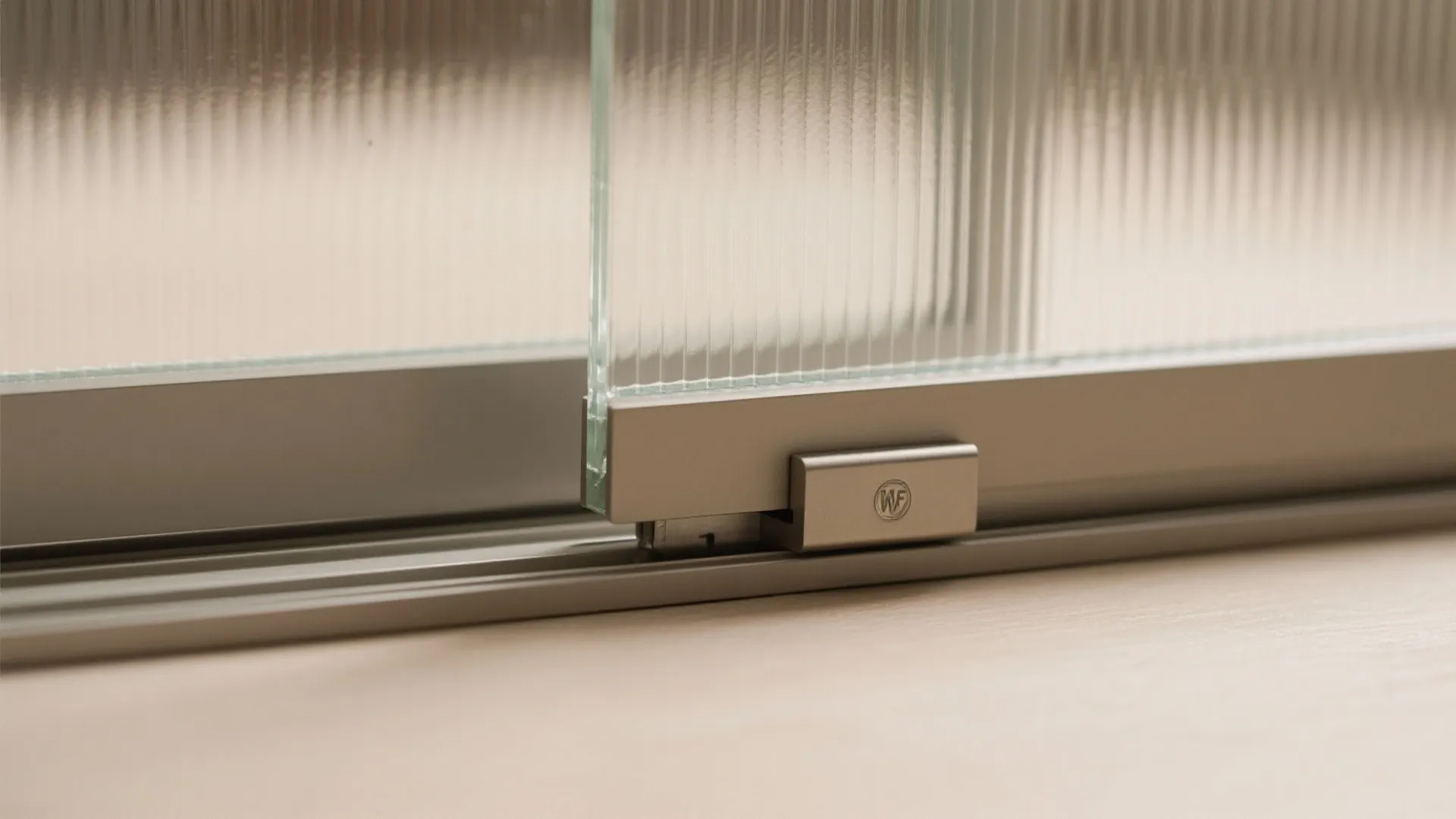 Close up of ribbed glass panel installed in a modern grey metal sliding door frame track