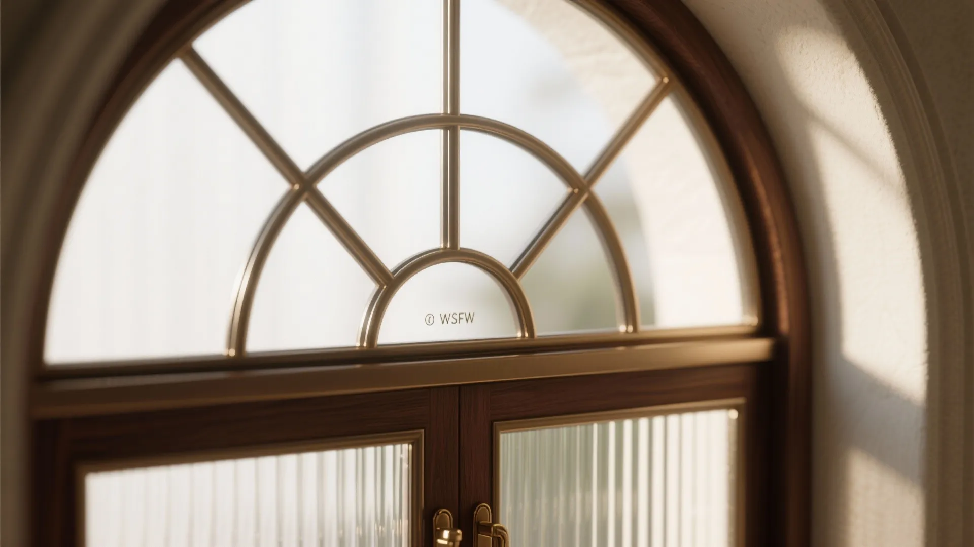 Close up of an arched wooden window with decorative gold metal patterns and textured glass panels