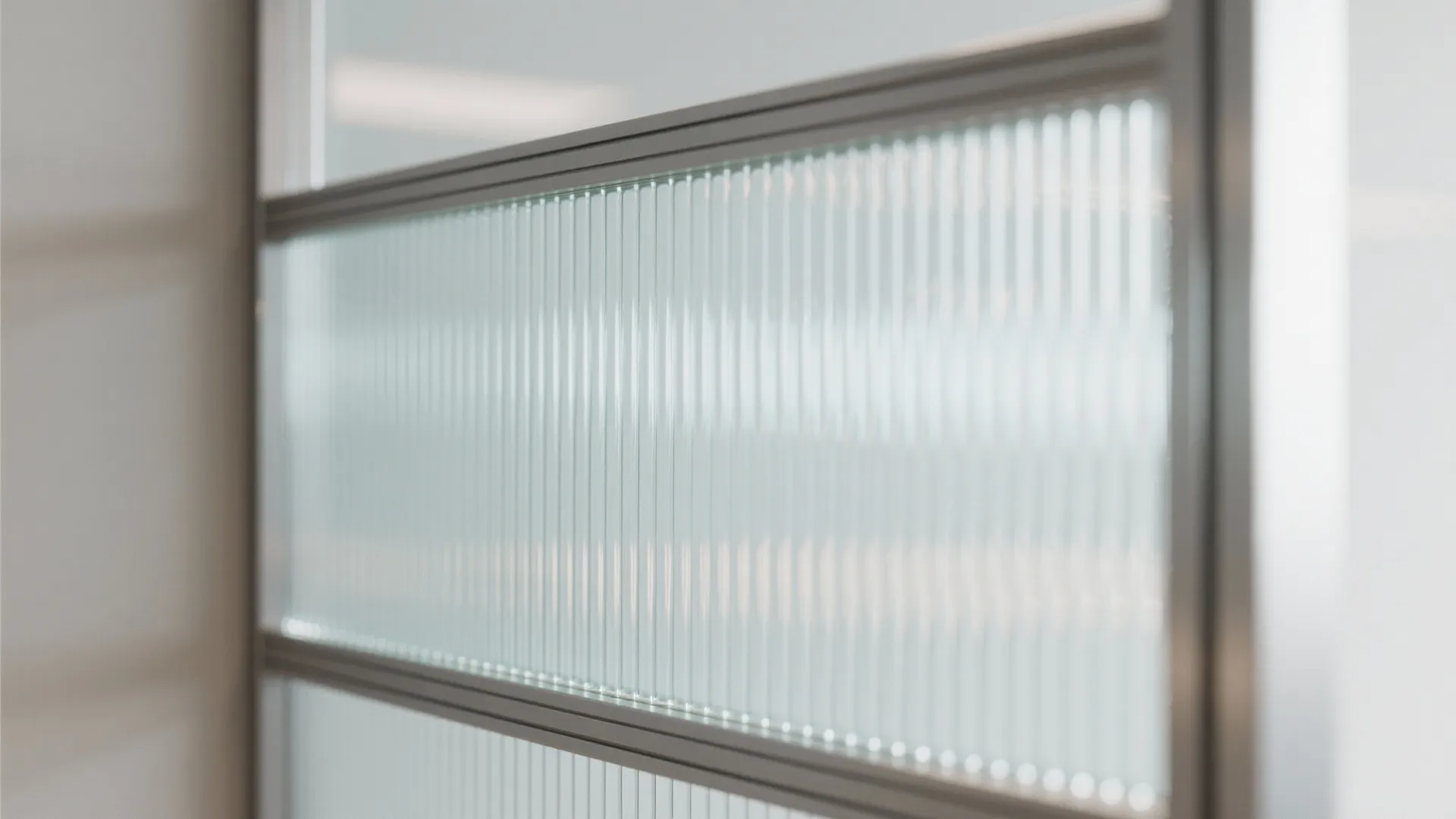 Close up of vertical ribbed glass panels set in a grey metal frame for modern interiors