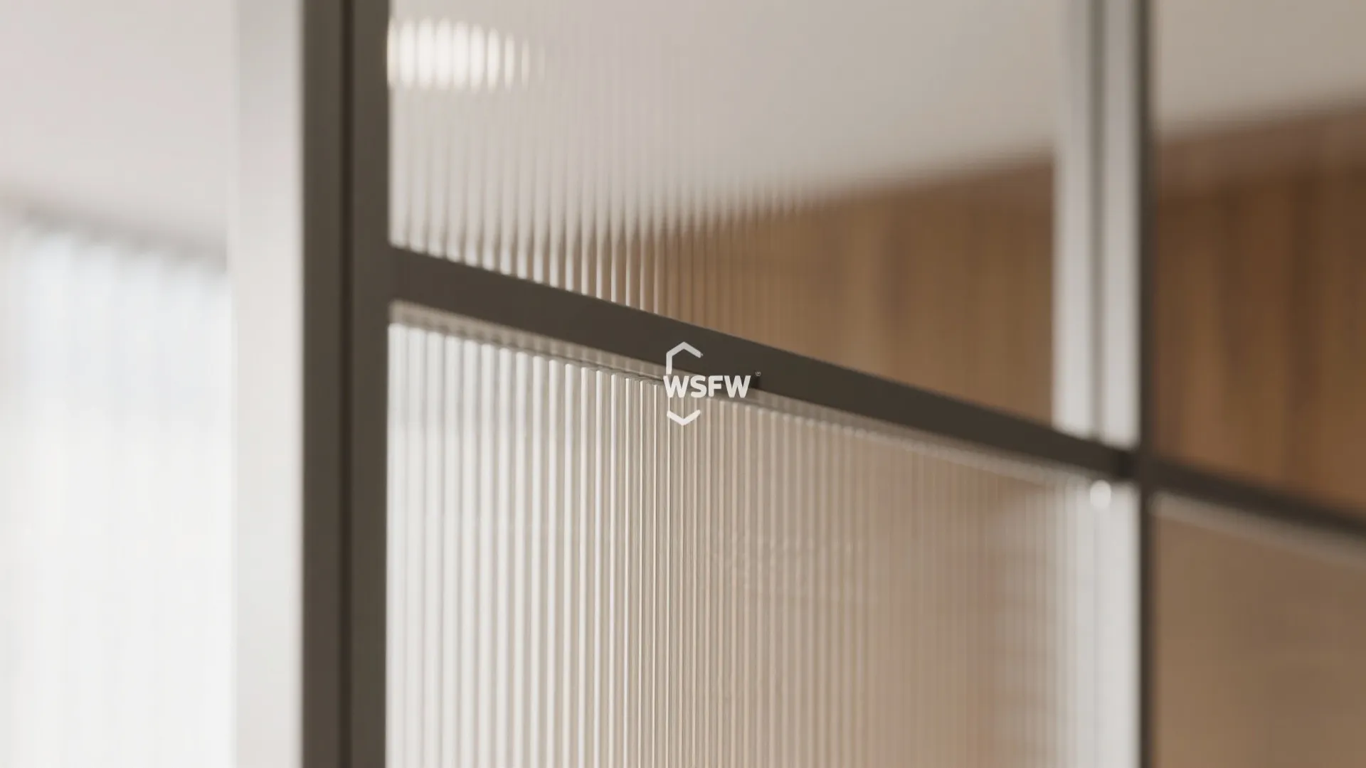 Close-up of fluted glass partition with brushed metal frame, softly diffusing daylight in a small bathroom.