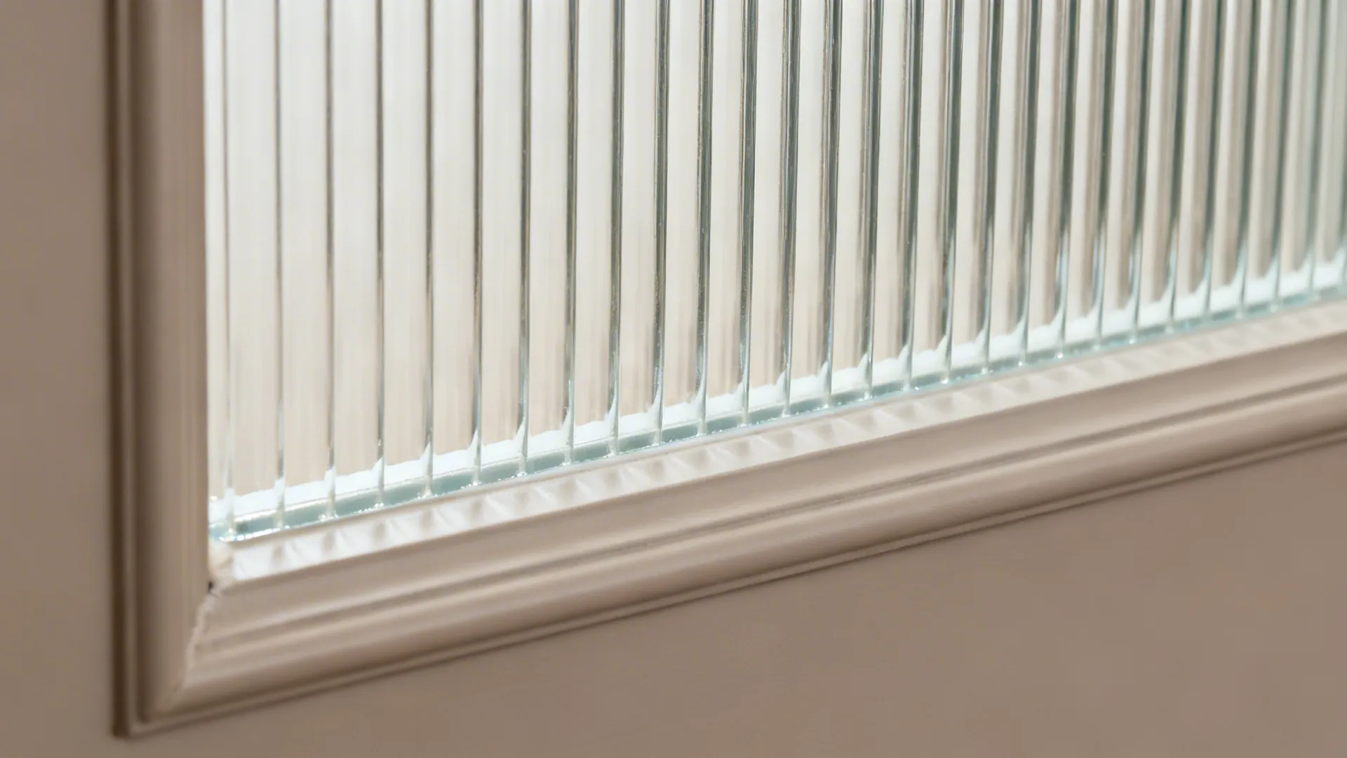 Macro of fluted glass texture within a matte PVC door frame.
