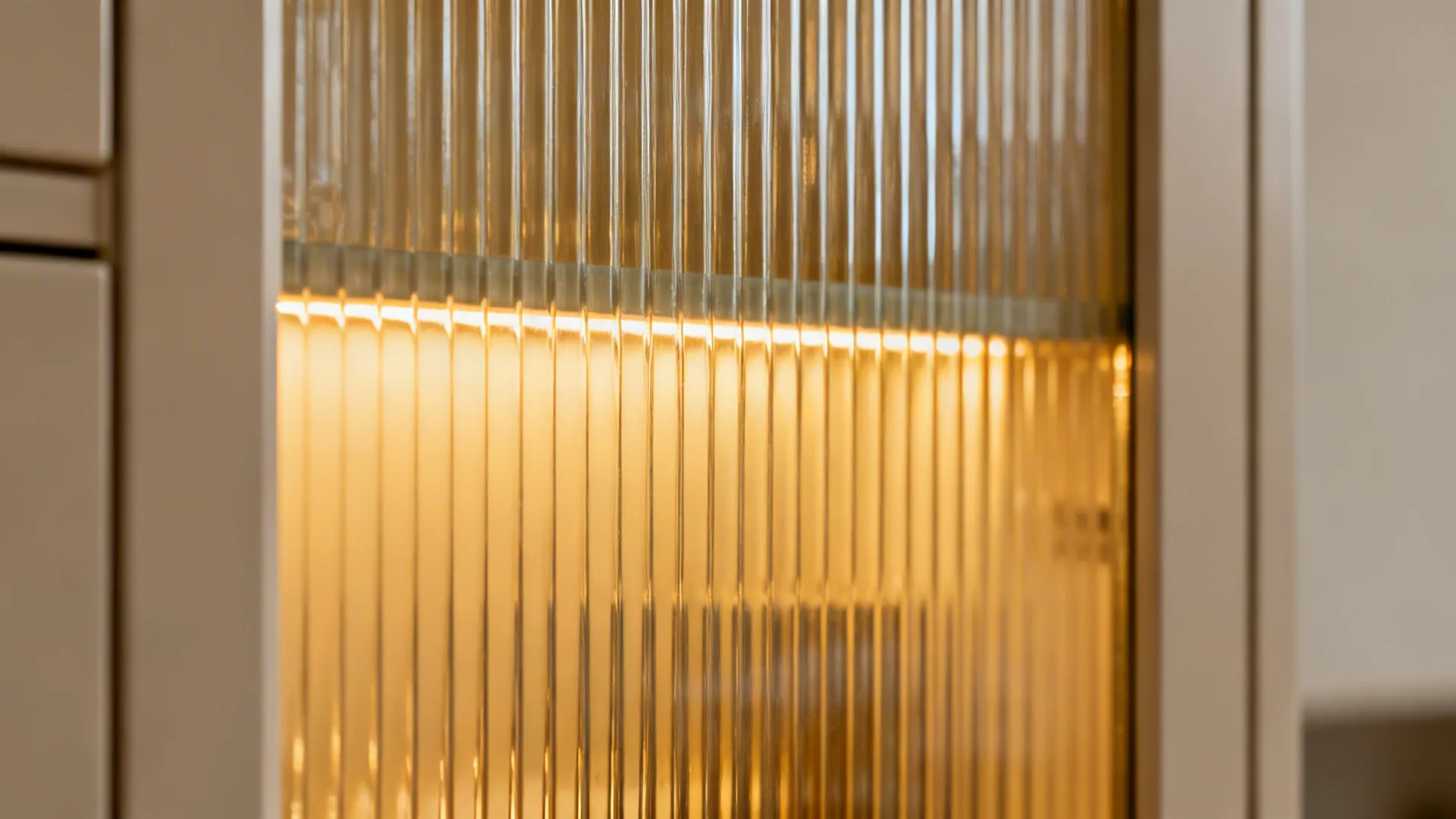 Macro of vertical fluted glass with warm diffused light behind the ribs.
