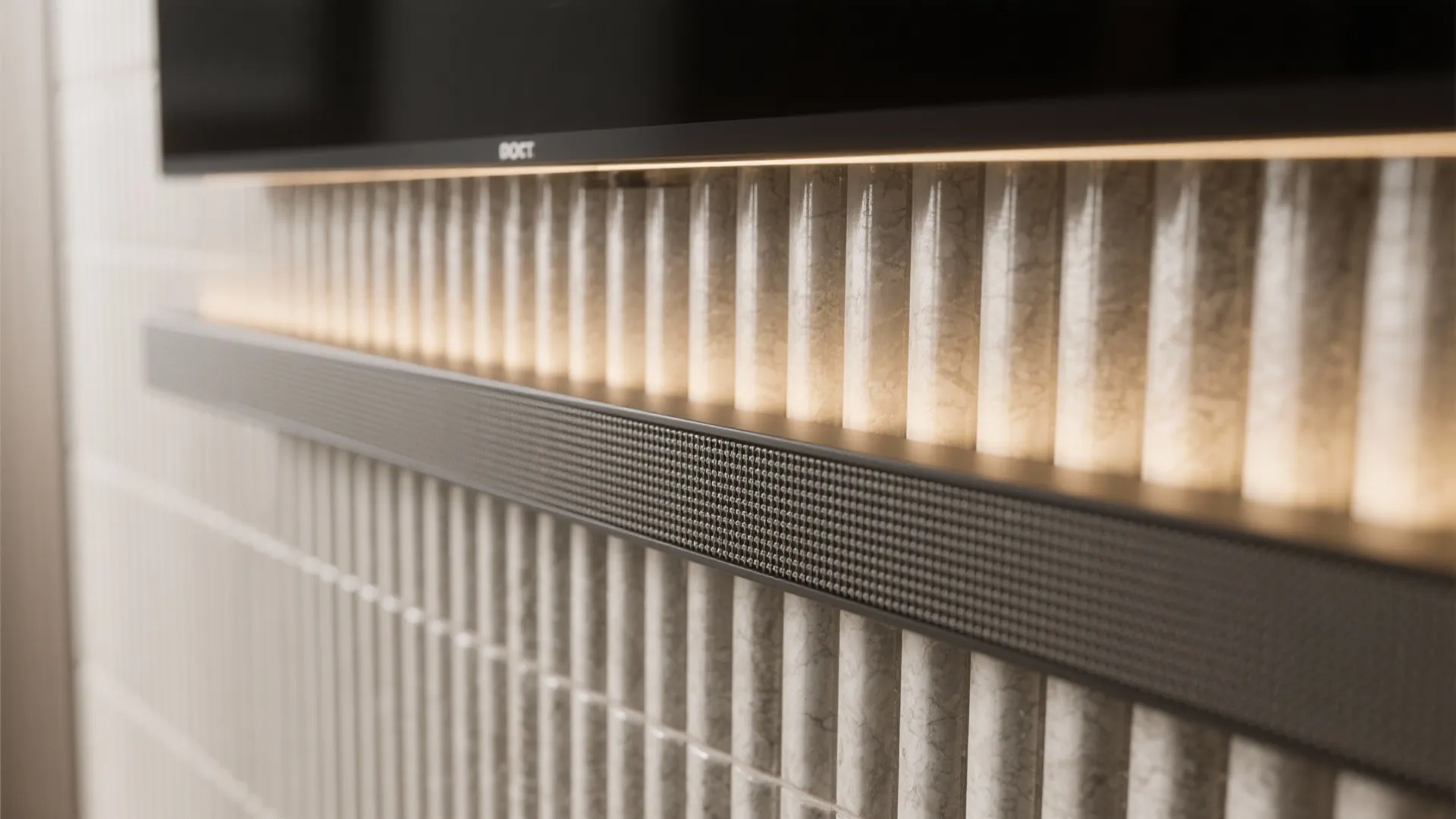 Macro view of fluted tiles on a TV wall with warm LED grazing light creating soft micro-shadows