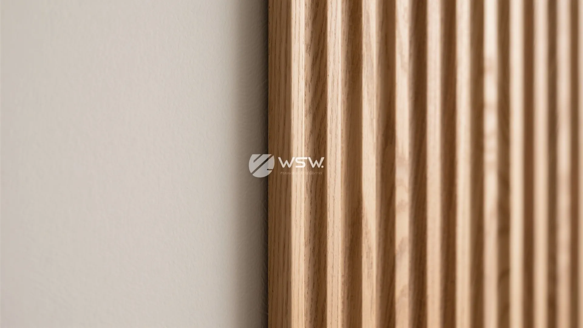 Vertical wooden wall panel slats next to a white wall showing natural wood grain texture