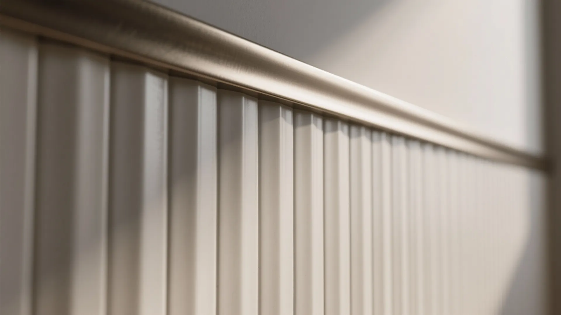 Close up shot of white fluted wall tiles with a gold metal trim on top