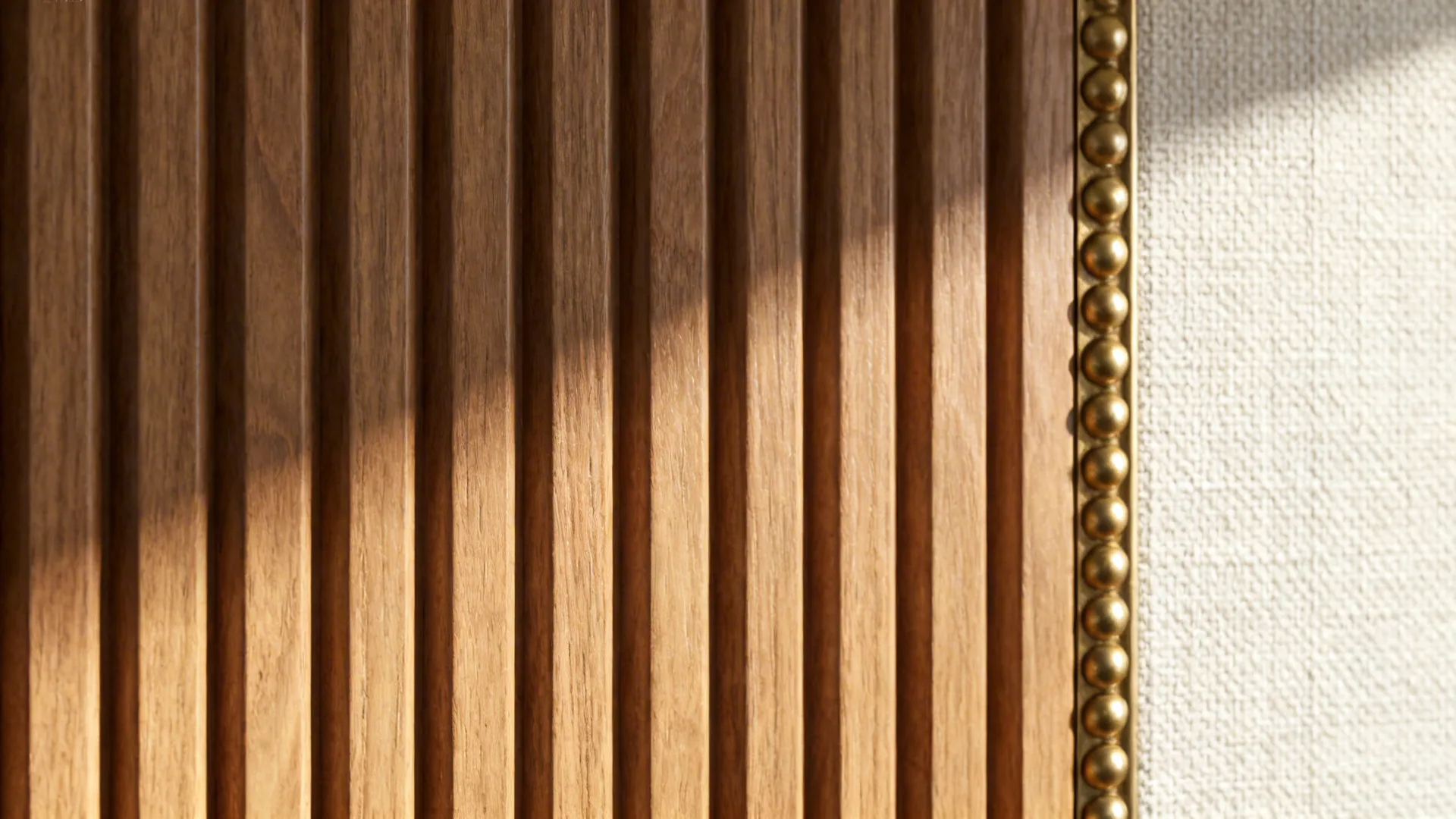 Macro of warm ash fluted wood-effect 3D wallpaper with brass trim and natural grain.