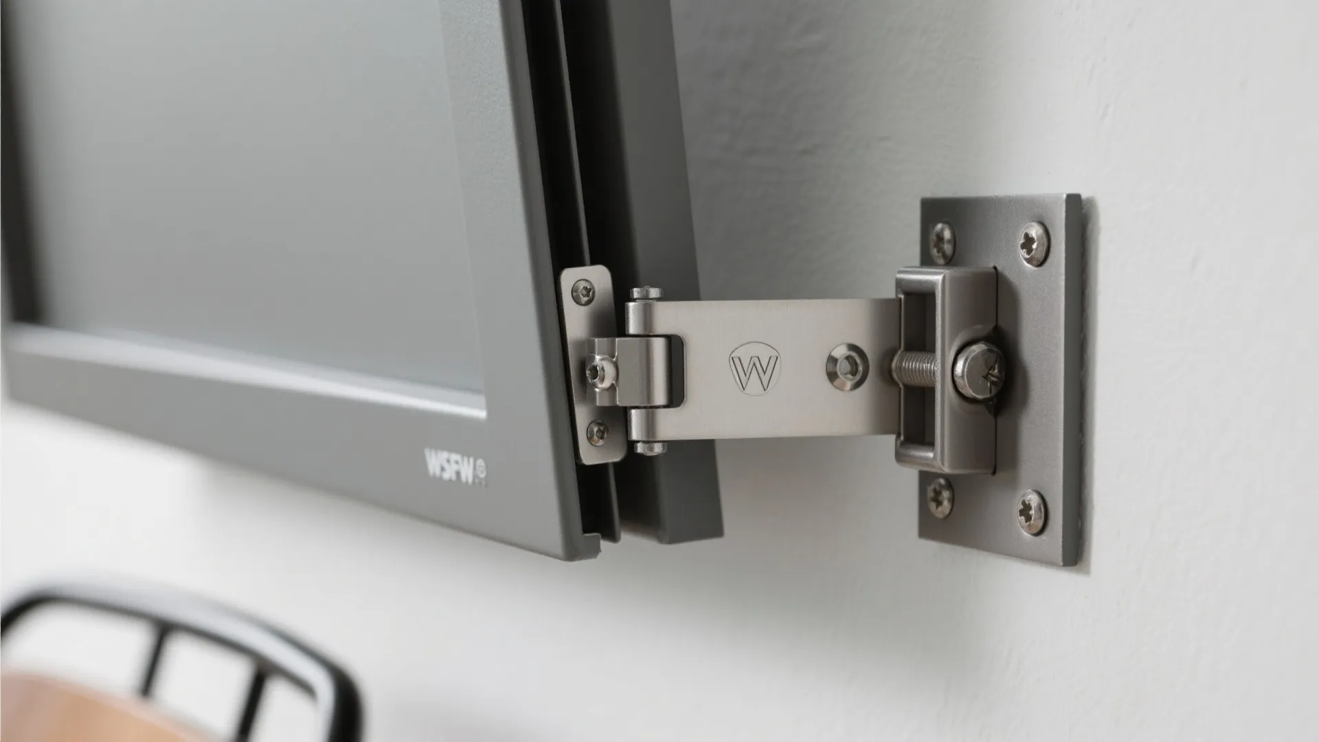 Macro of fold-down chair hinge and magnetic latch anchored securely to a stud.