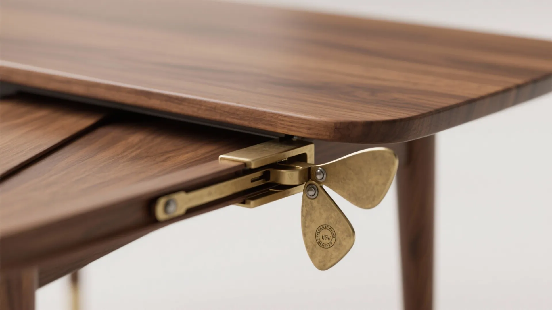 Close-up of a butterfly leaf hinge and joinery on a slim oblong dining table, showing mechanism detail.